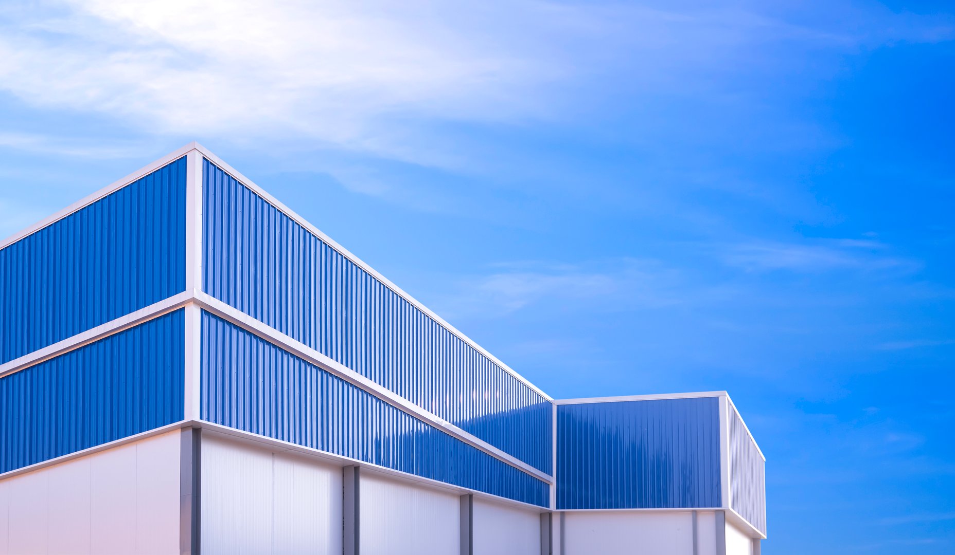 Dark warehouse industrial roof absorbing heat in Dubai climate