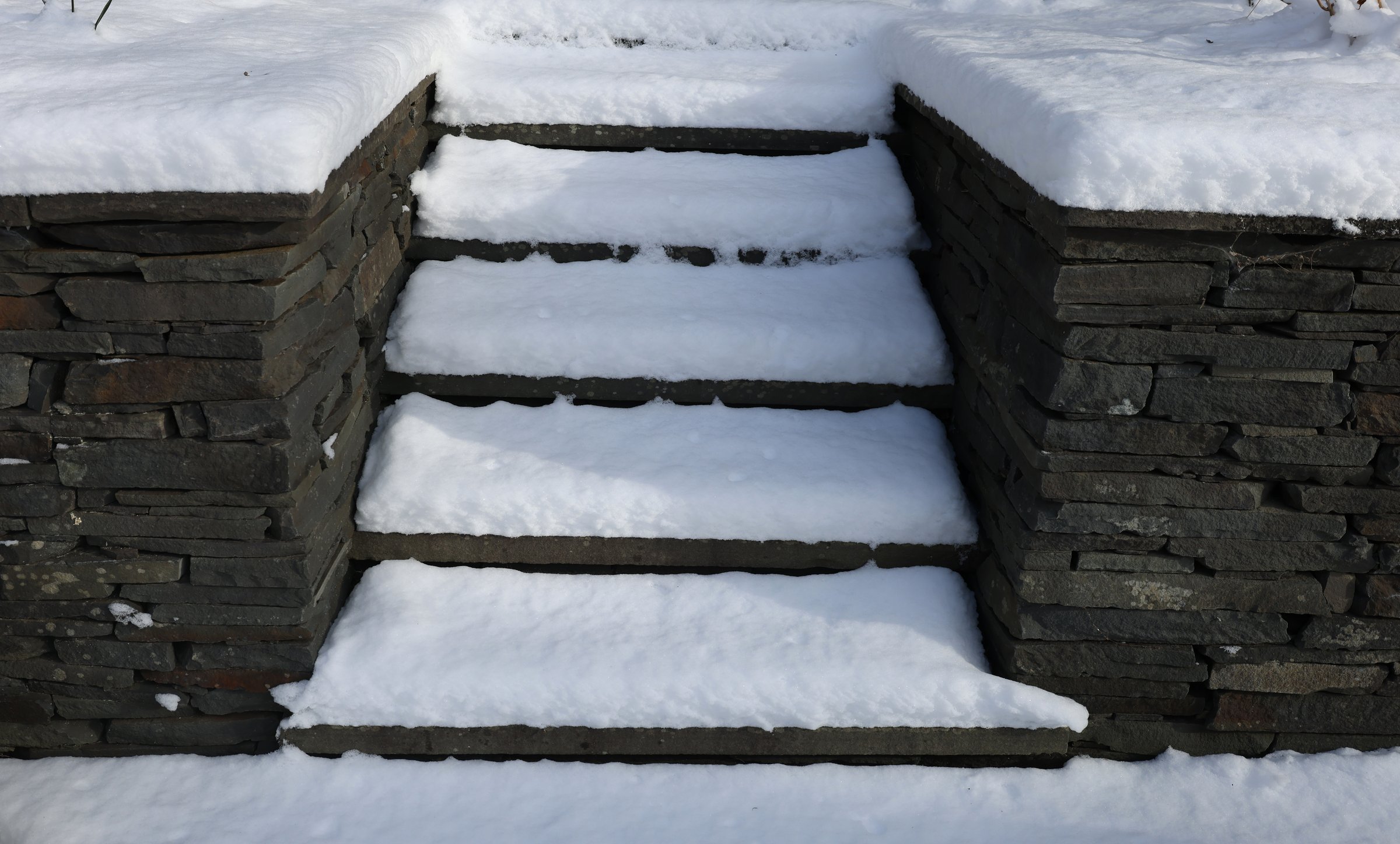 back yard patio stairs covered in snow during winter blizzard (snowy conditions in northeast united states new york state) dangerous slippery frozen icy