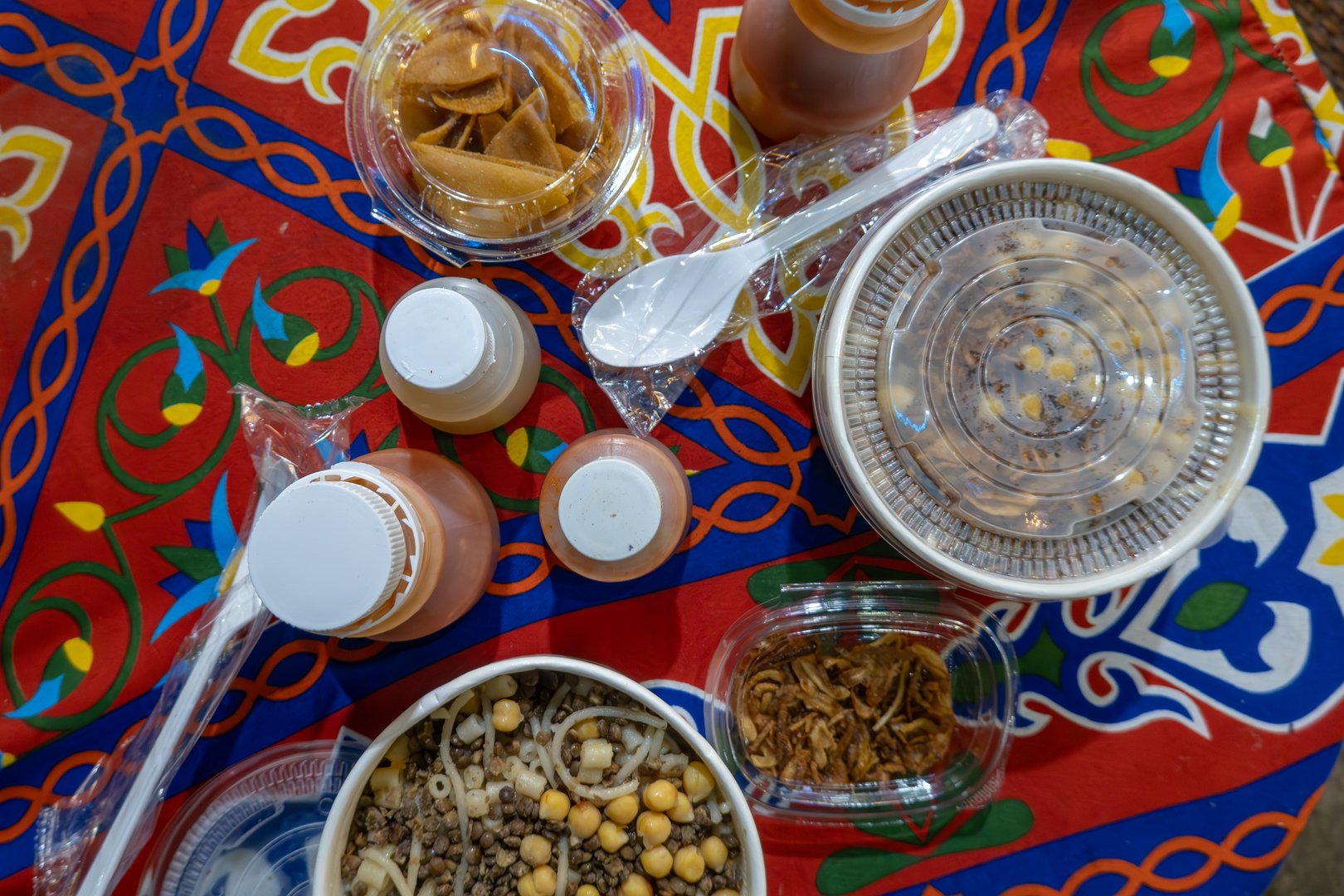 Cairo, Egypt A tabletop with Egyptian koshery in take away containers with garlic, hot sauce, and chickpeas.