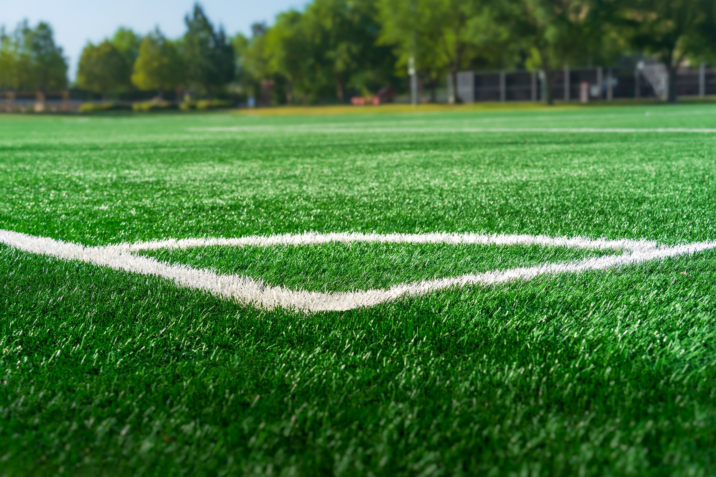 Soccer field corner white marking with artificial synthetic green grass turf