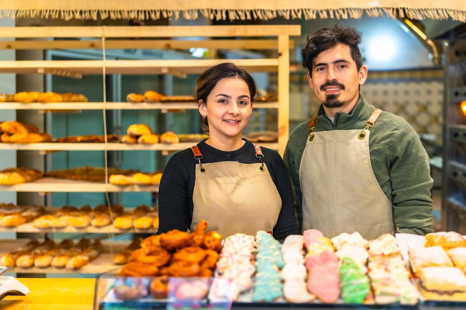Portrait of male and female latin young coworkers in an artisan bakery shop