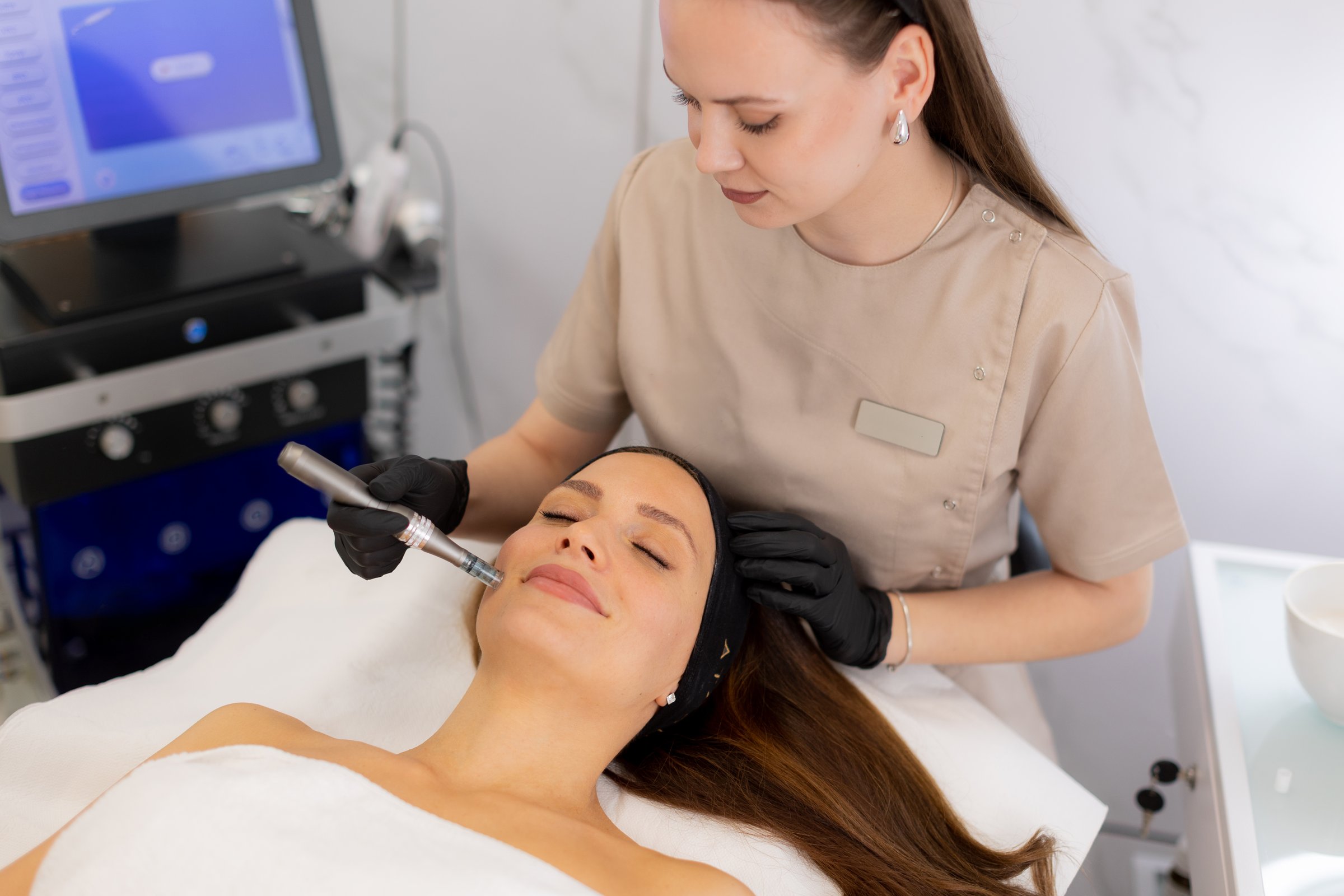 A skilled practitioner uses a microneedling mesotherapy device to revitalize a client's skin. The serene beauty clinic atmosphere complements the transformative treatment experience.
