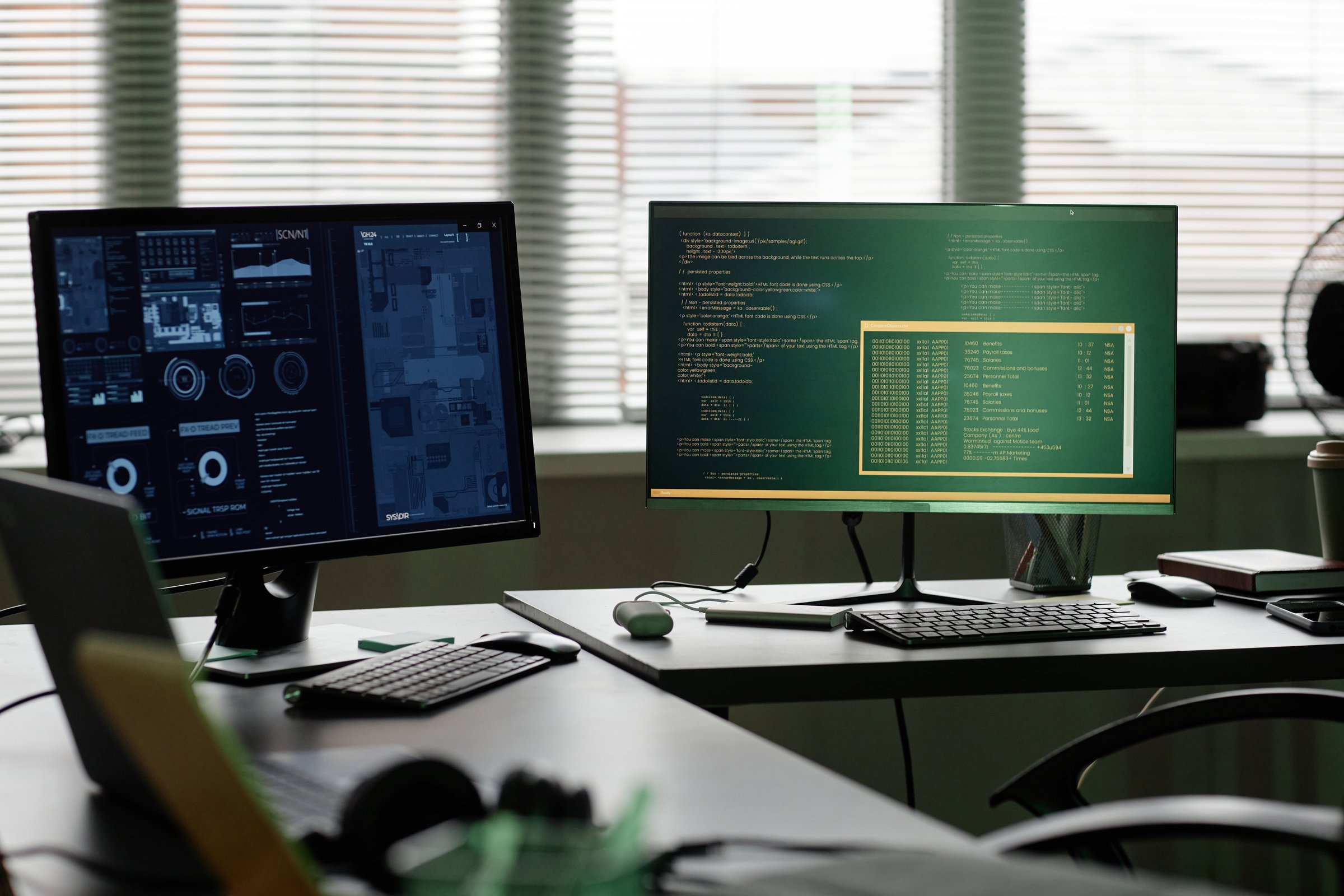 Background shot of computers with programs running on screens standing on software developers professional workstation captured against window in office