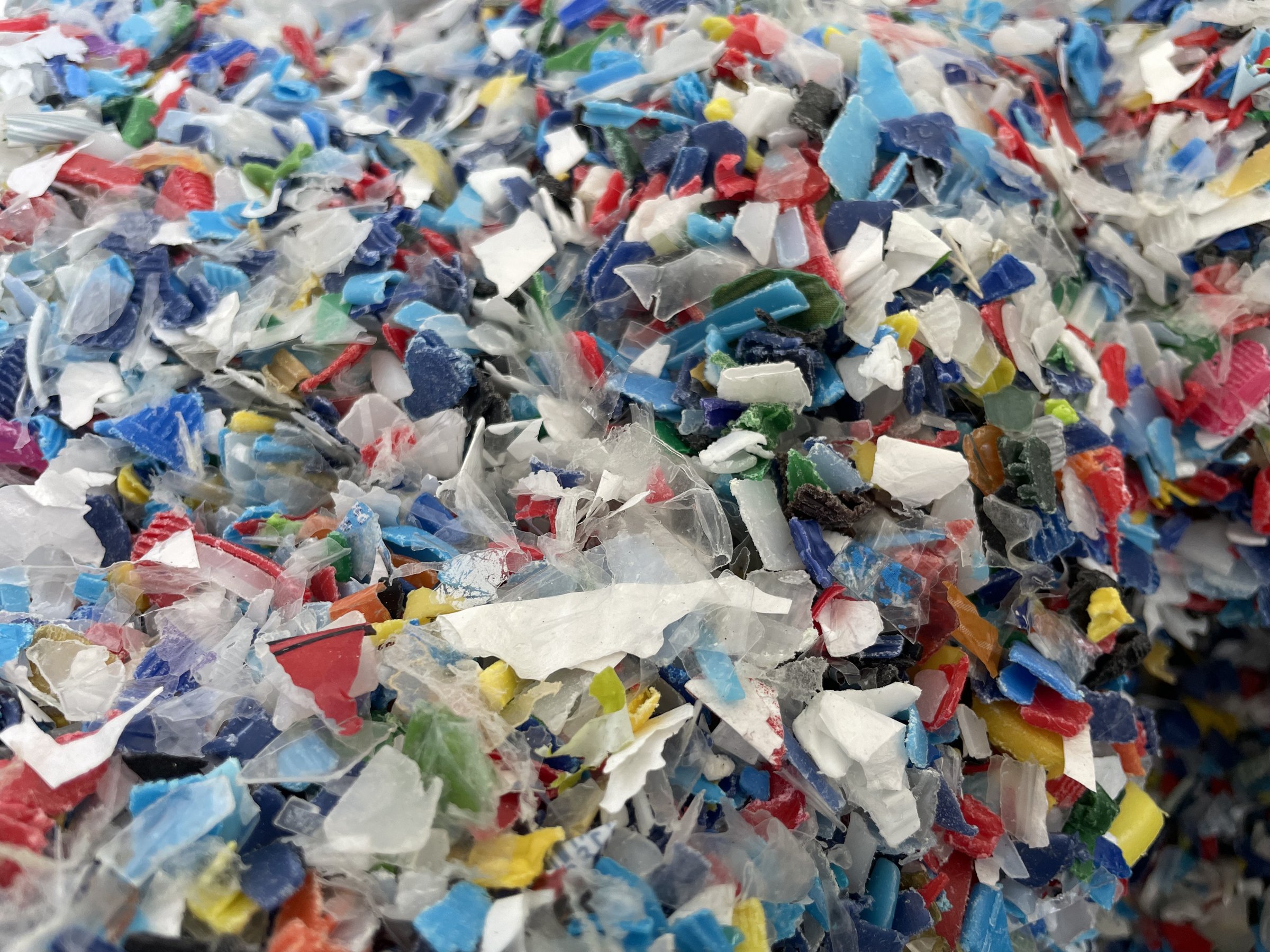Closeup image of colorful plastic flakes. Concept pollution, environment, save the planet. PP plastic recycling from bottles. Bottle cap. PET bottle recycled. High quality photo