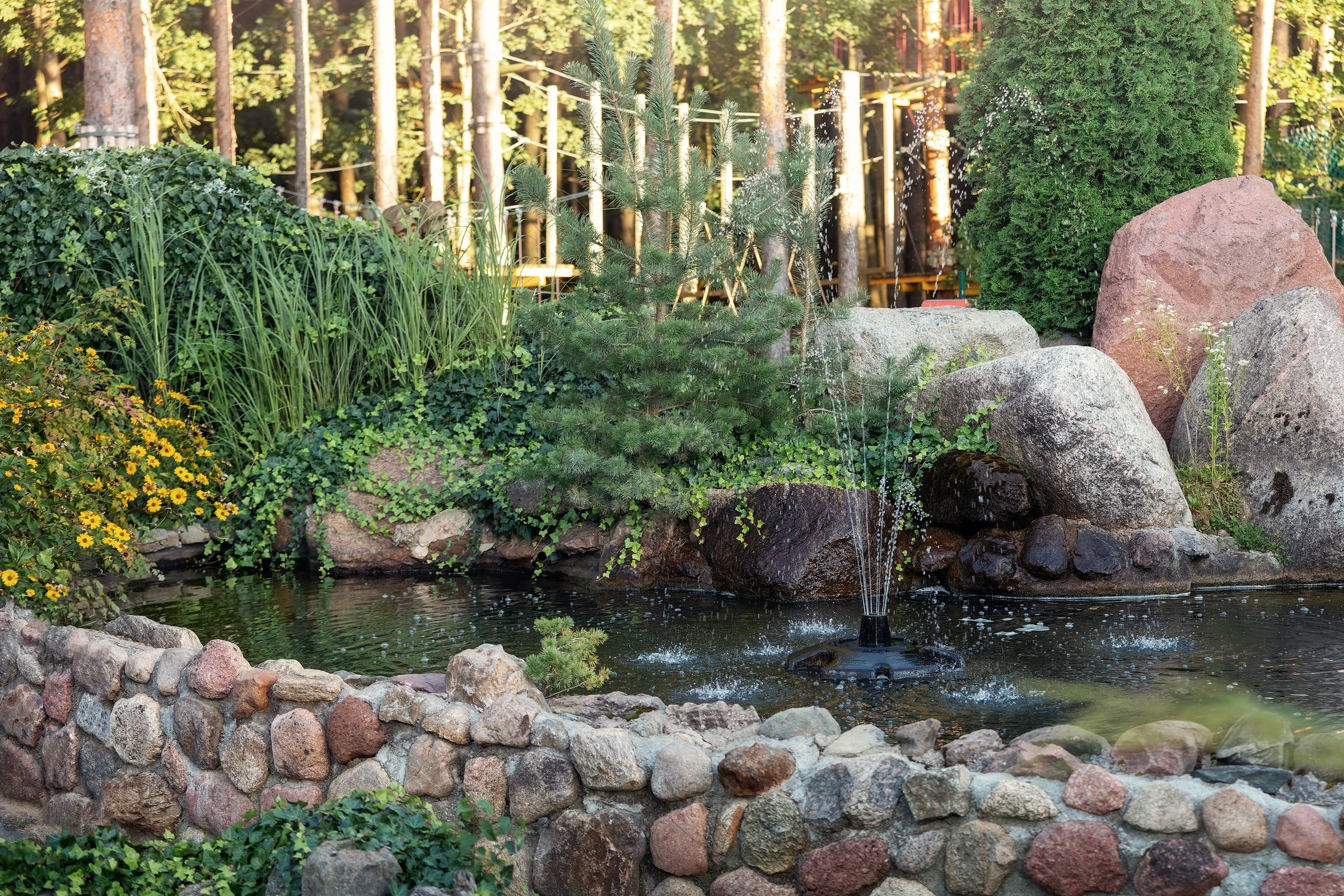 Outdoor decorative pond in the flower garden with fountain.