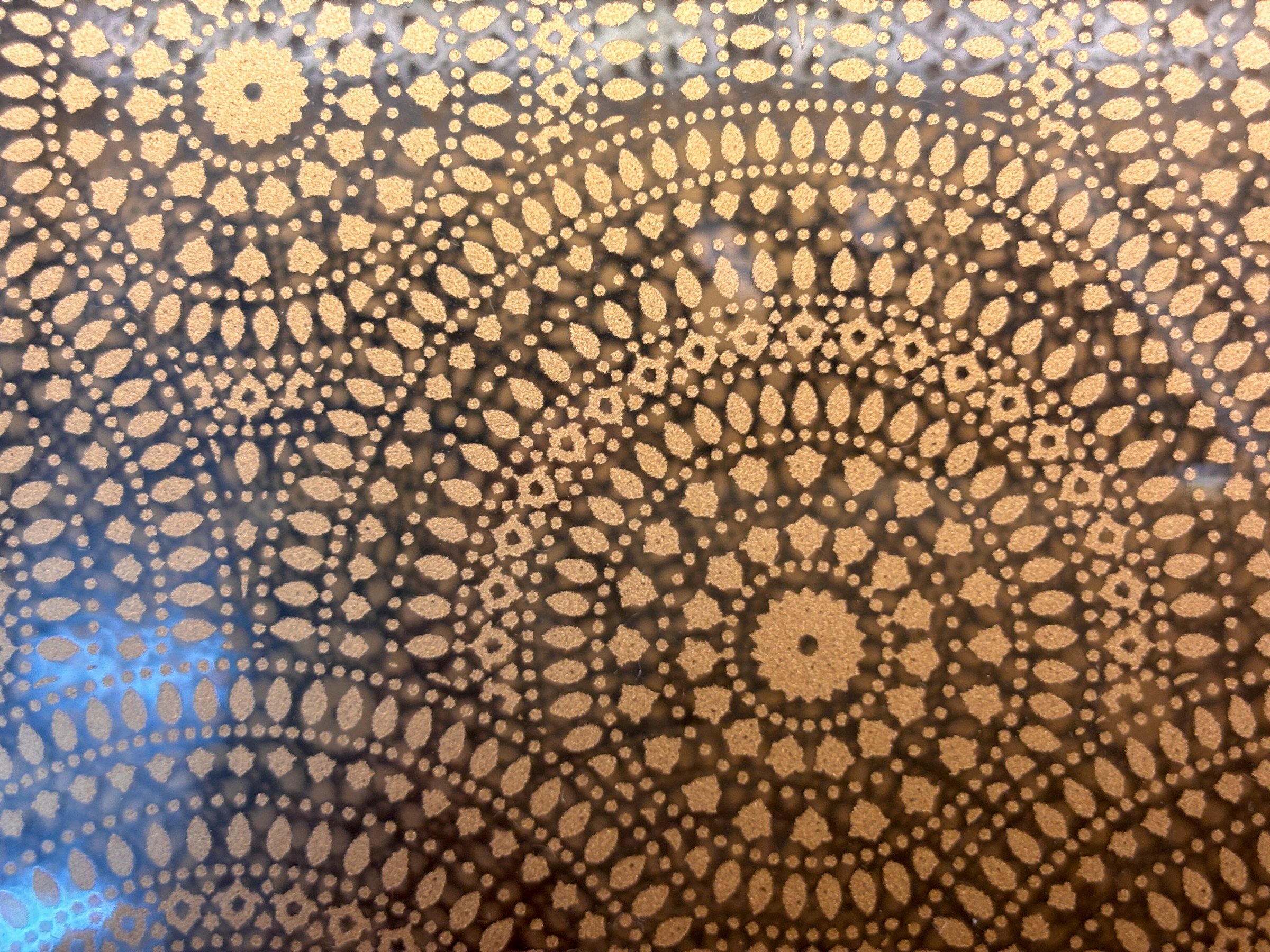 A patterned background with a circle in the center. The circle is surrounded by smaller circles. The background is brown and the circles are white