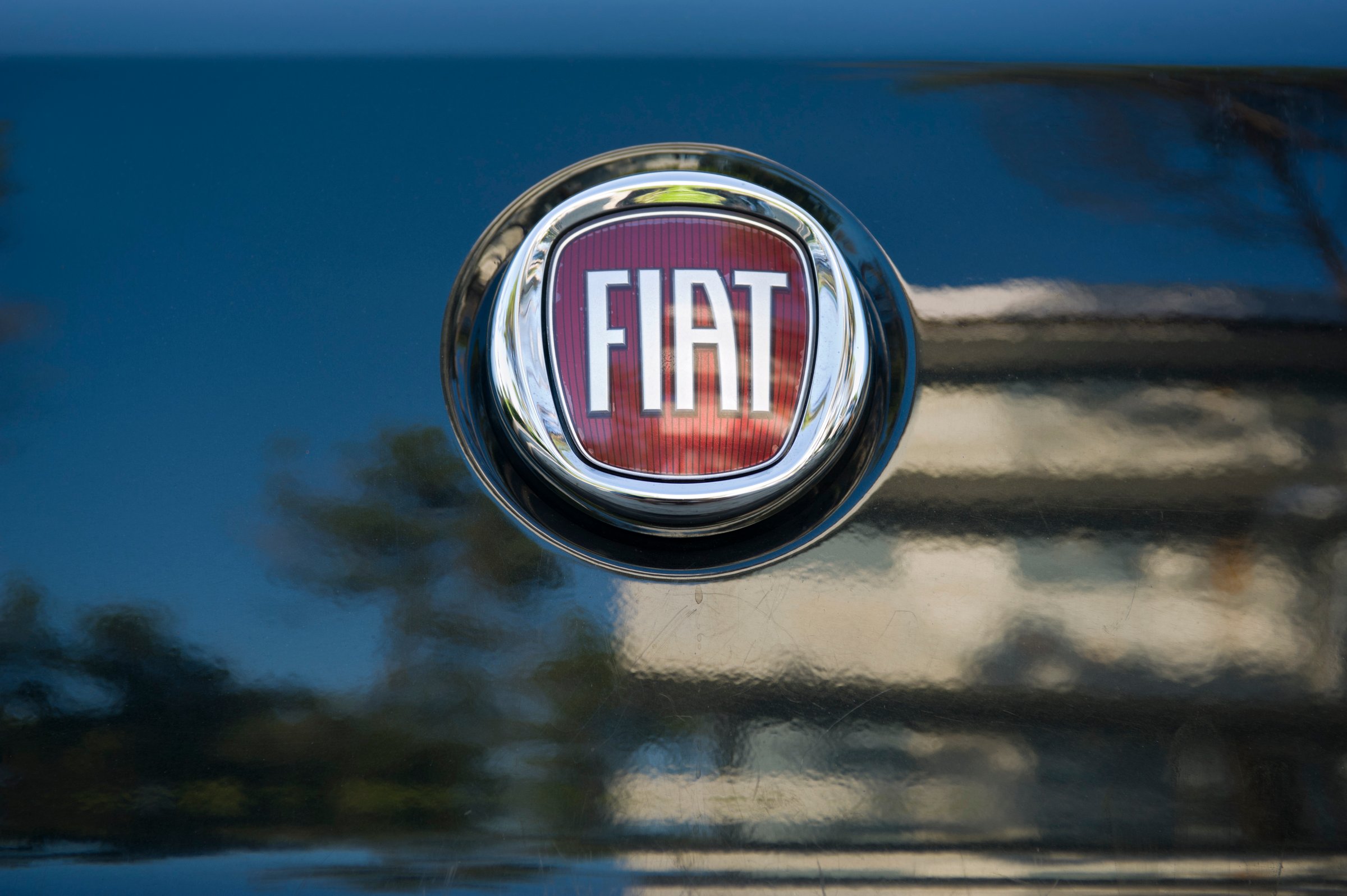 Padua, Italy - July 9, 2011: Fiat metallic logo on a car rear hood. Fiat Automobiles S.P.A. is an Italian automaker which produces Fiat branded cars since 1899. Shot in a public parking.