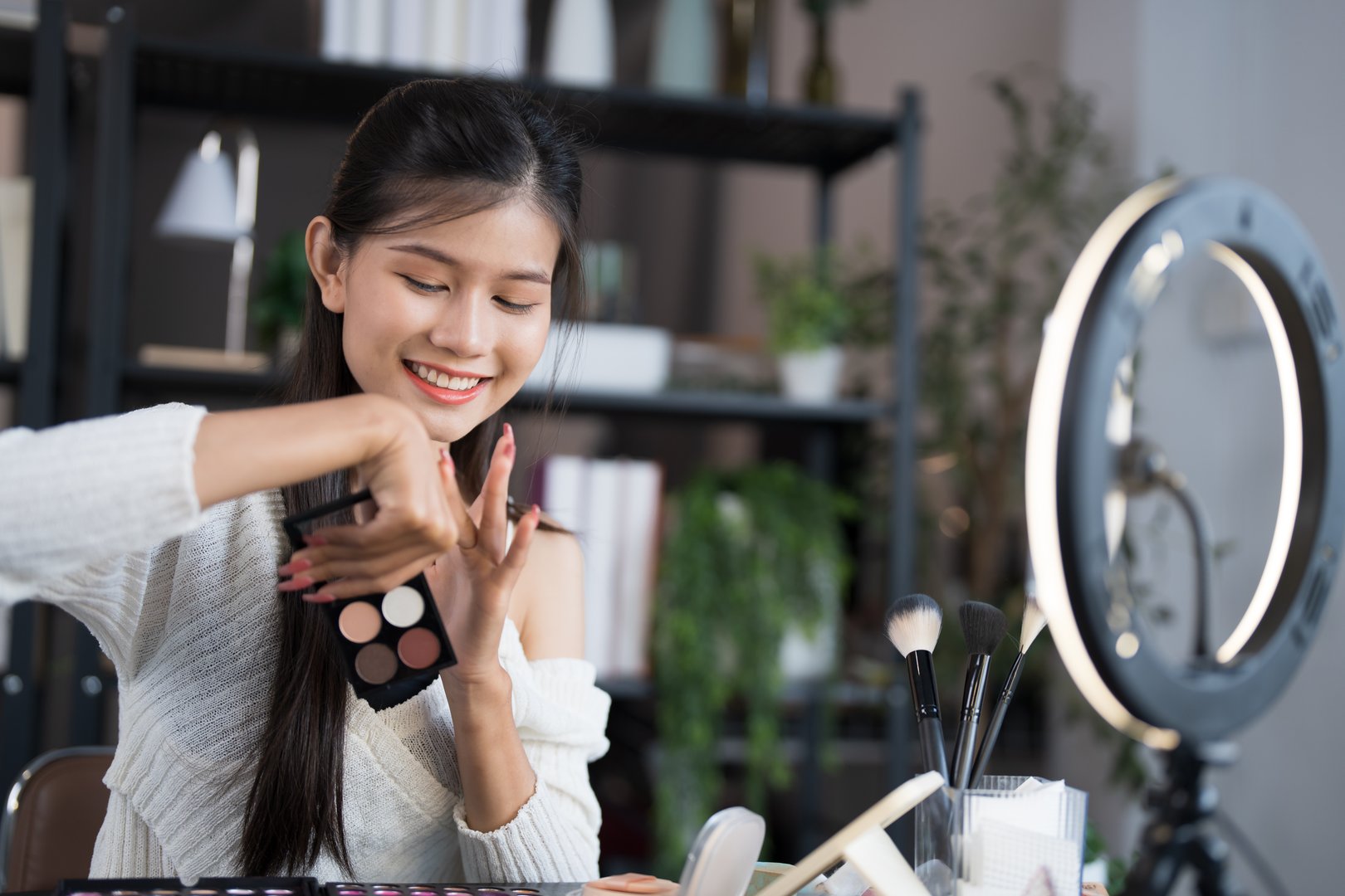 beauty blogger Young Asian girl makeup artist Professional Woman blogger vlogger is showing cosmetics products with recording videoÂ Beauty influencer asian girl video online marketing live streaming.