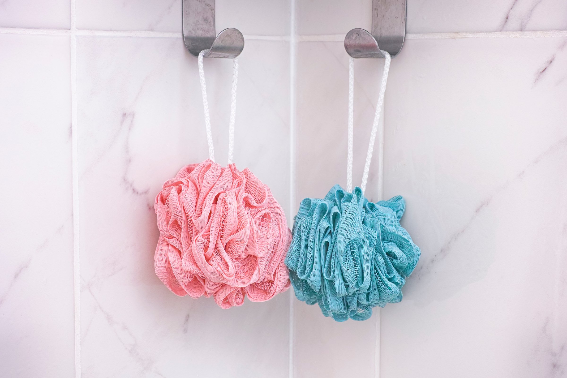 Pink and blue shower scrubbers. Close up.