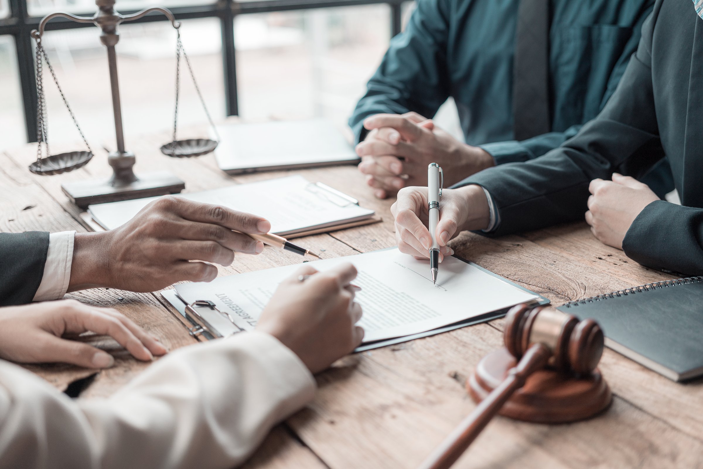 Lawyer giving legal advice to couples regarding purchasing a rental home. Financial advisor with investment contract, mortgage loan, real estate, close-up pictures