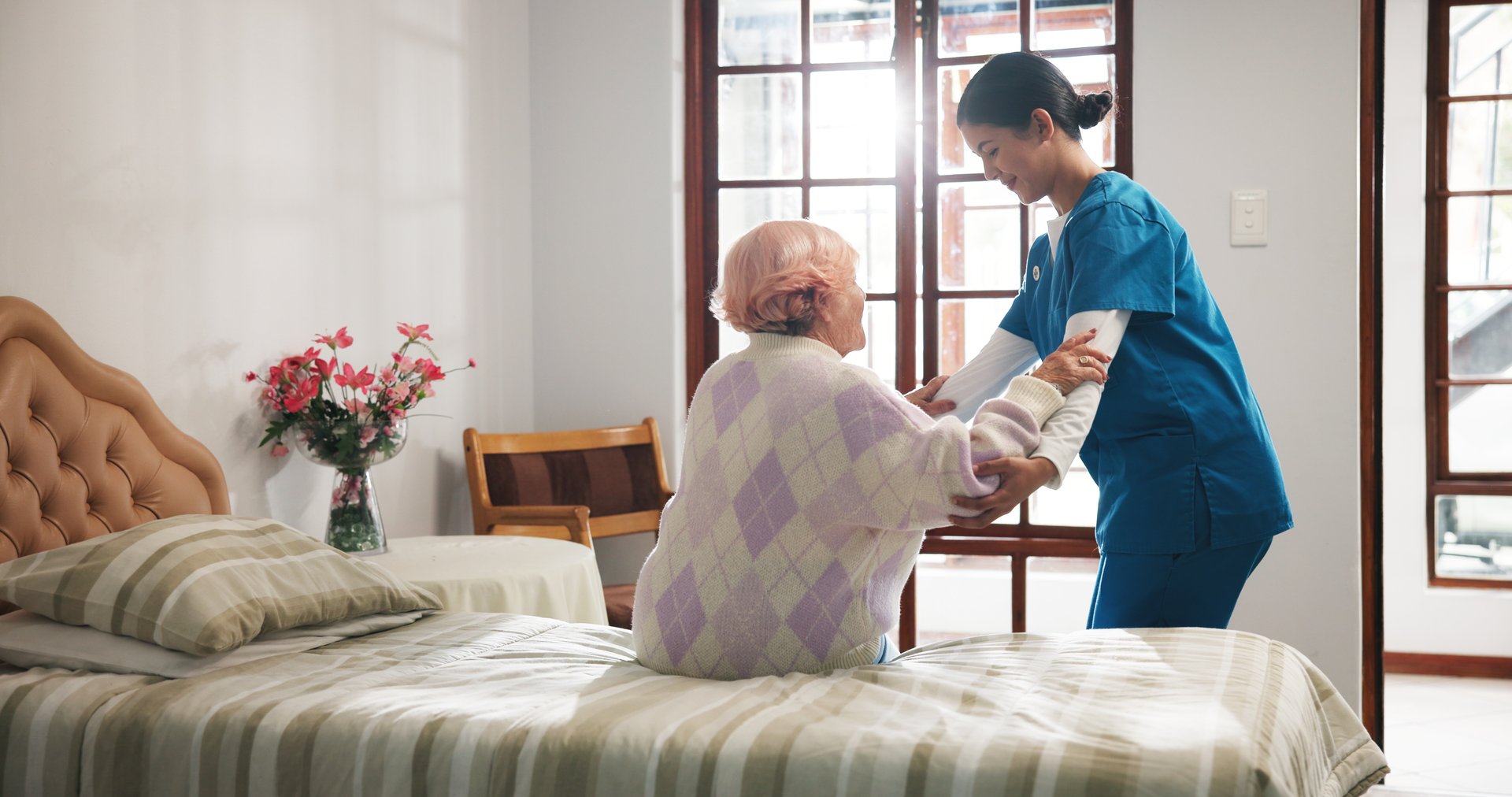 Senior woman with caregiver and mobility aid in bedroom