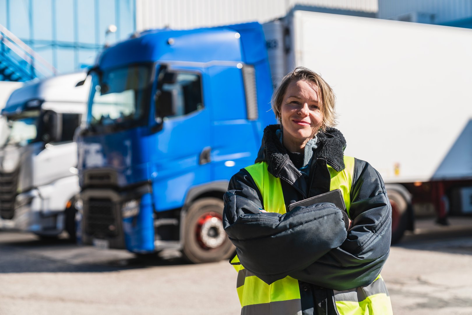 Woman truck driver in workwear standing with folded arms