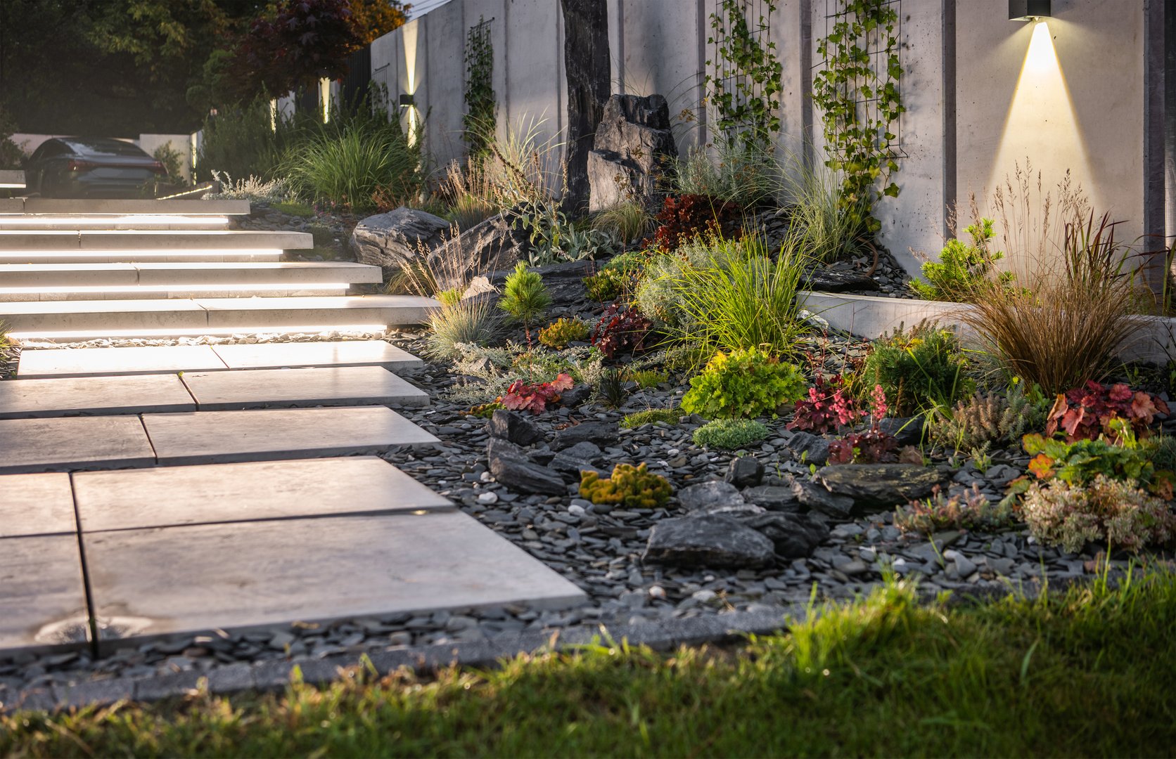 Illuminated Residential Backyard Garden by LED Lights. Modern Architectural Concrete Wall and Stairs Elements Design.