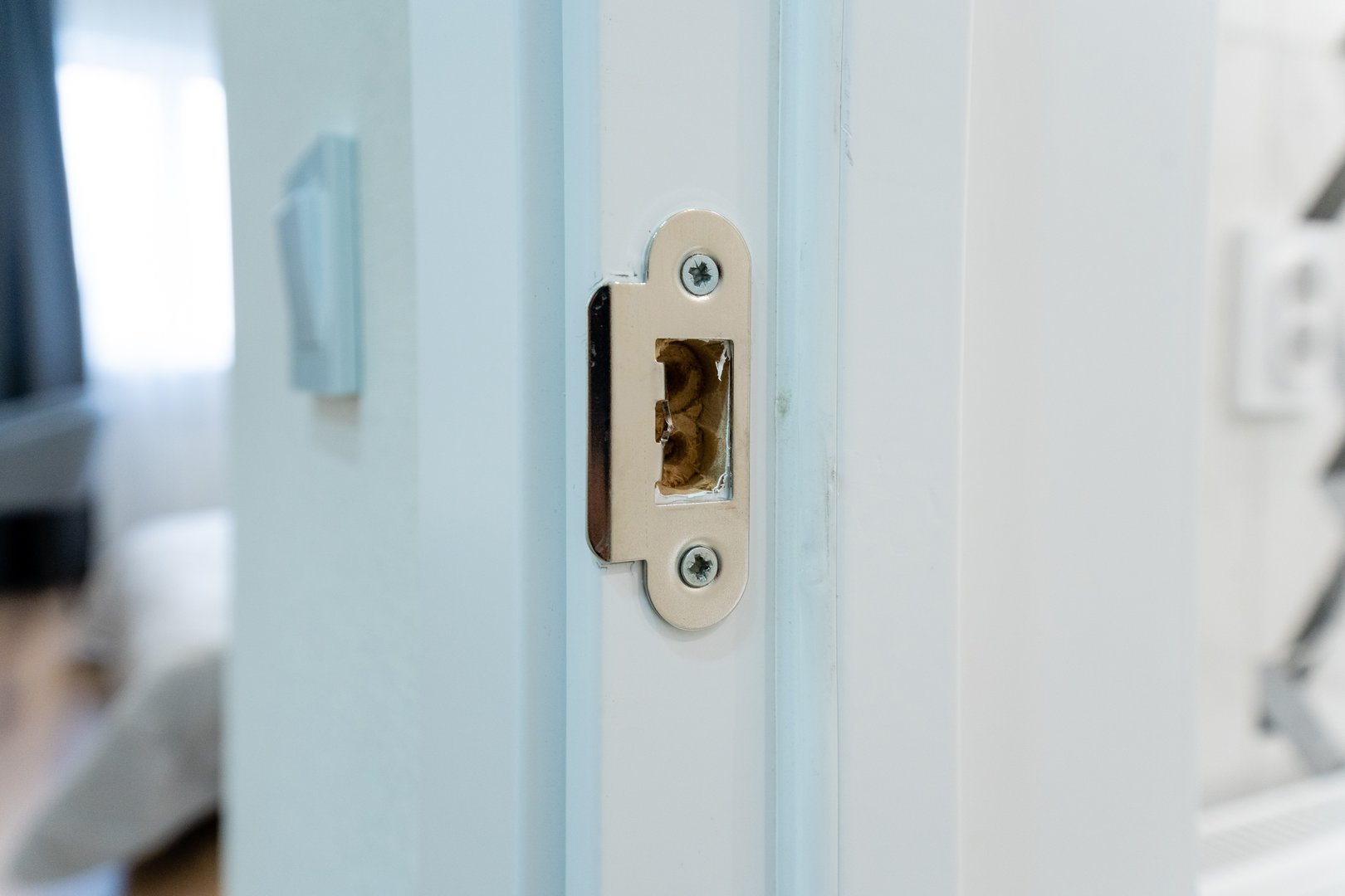 This image features a detailed closeup view of a door latch mounted on a pristine white door, showcasing the intricate design and craftsmanship involved in this essential fixture