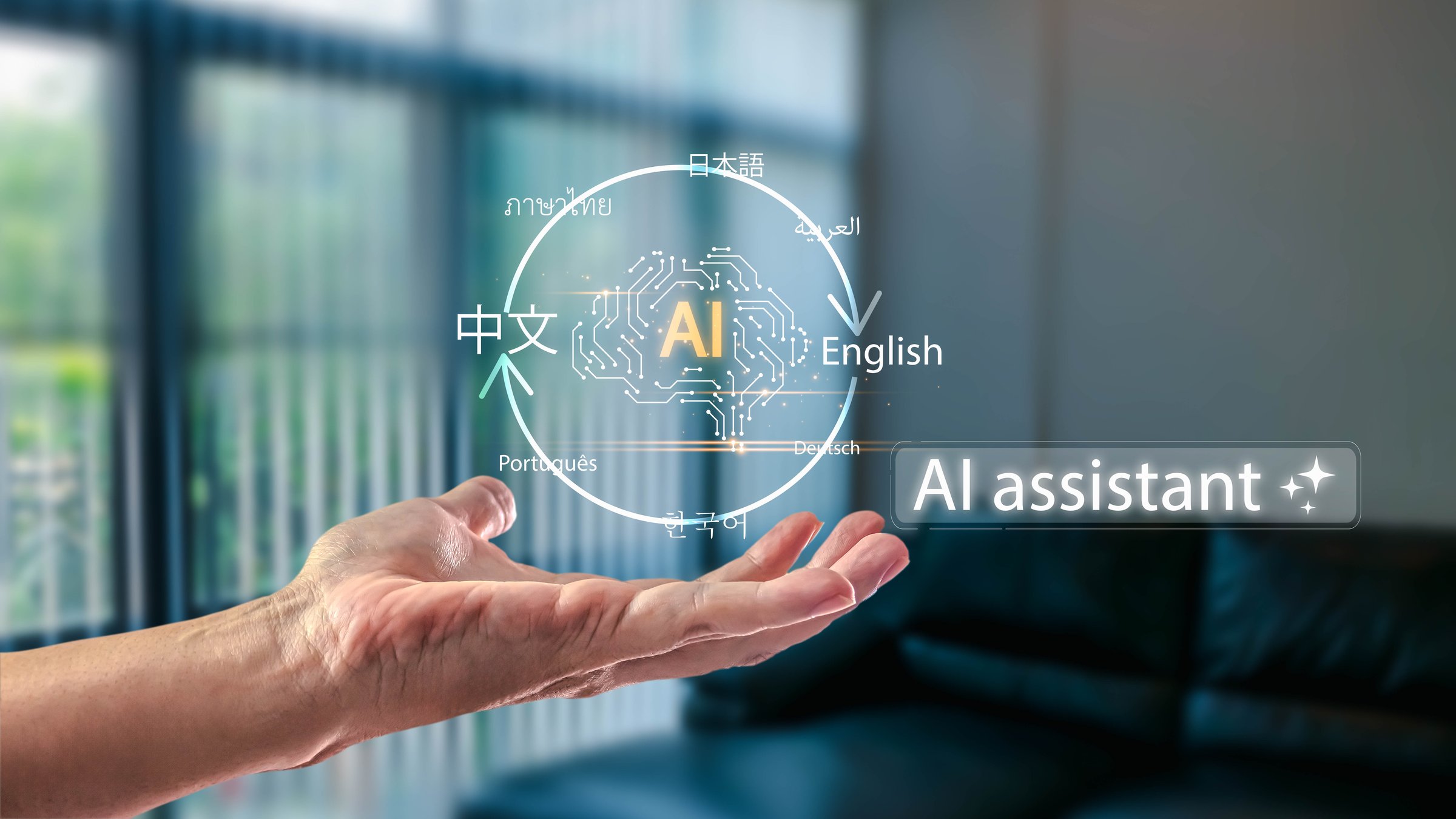 Hand holding a futuristic AI brain hologram for a multilingual translation app. This AI assistant technology helps with global communication in a modern home office.