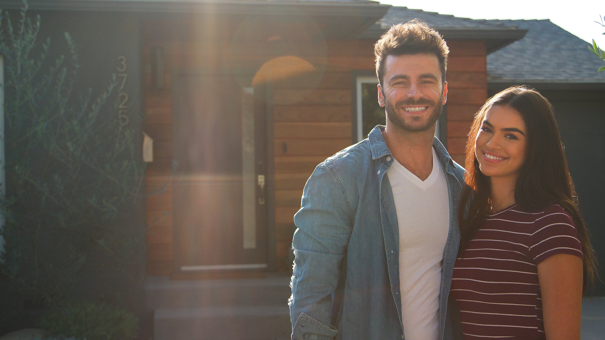 Portrait Of Hugging Couple Standing Outdoors In Front Of House
