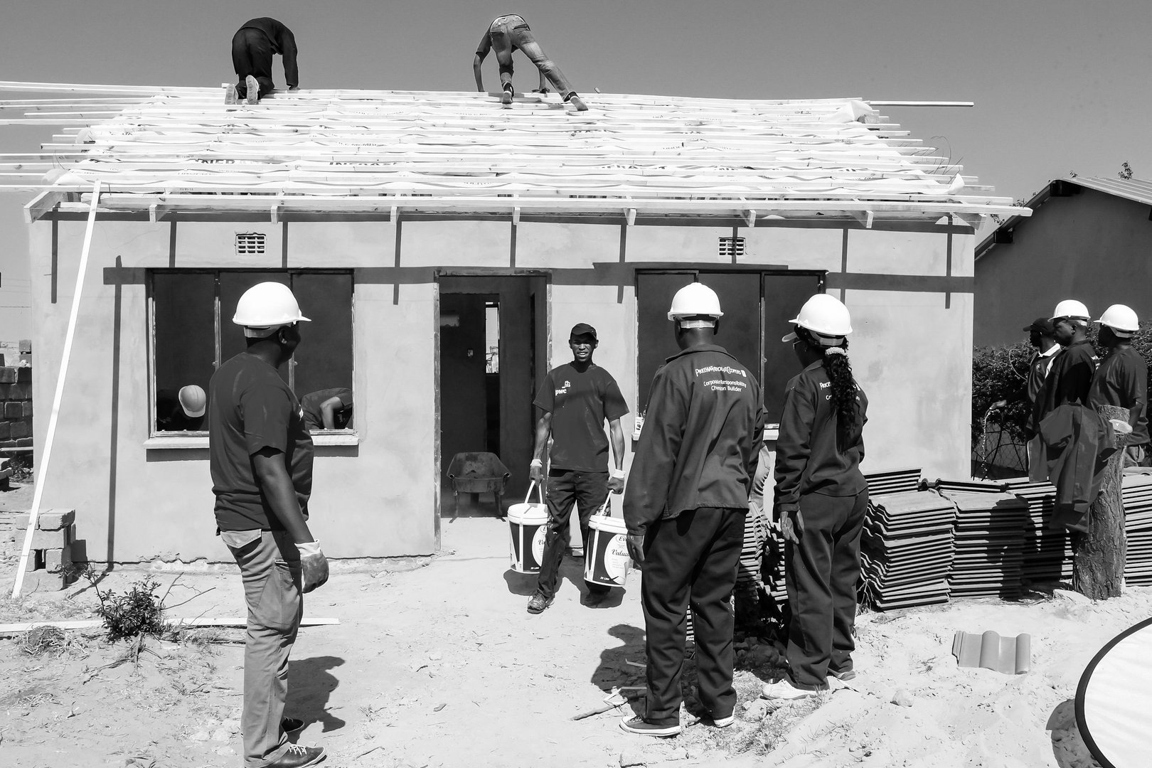 Johannesburg, South Africa – July 06, 2022: A greyscale shot of construction workers building a house