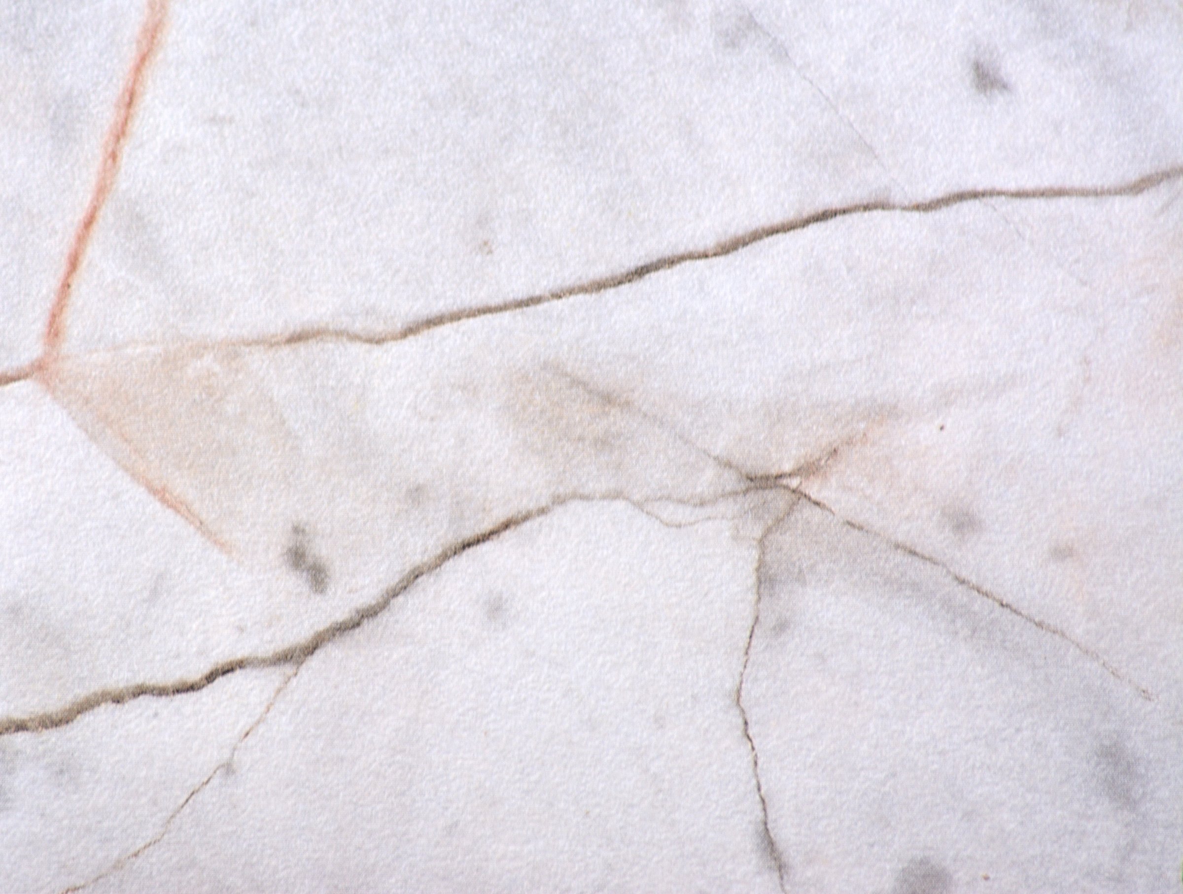 Gray marble, polished natural stone surface with deep black and orange cracks throughout the material, close-up.
