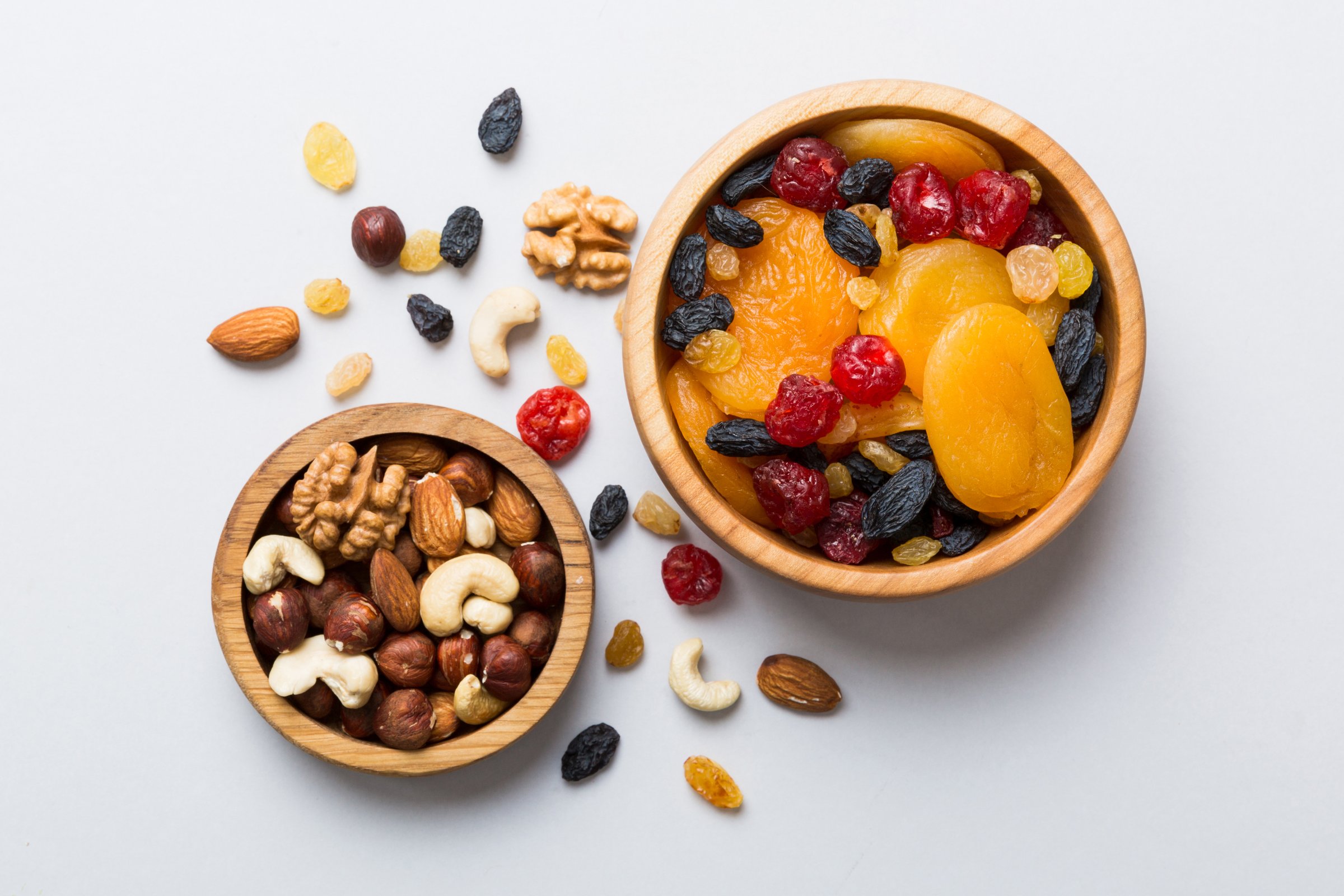 healthy snack: mixed nuts and dried fruits in bowl on table background, almond, pineapple, cranberry, cherry, apricot, cashew.
