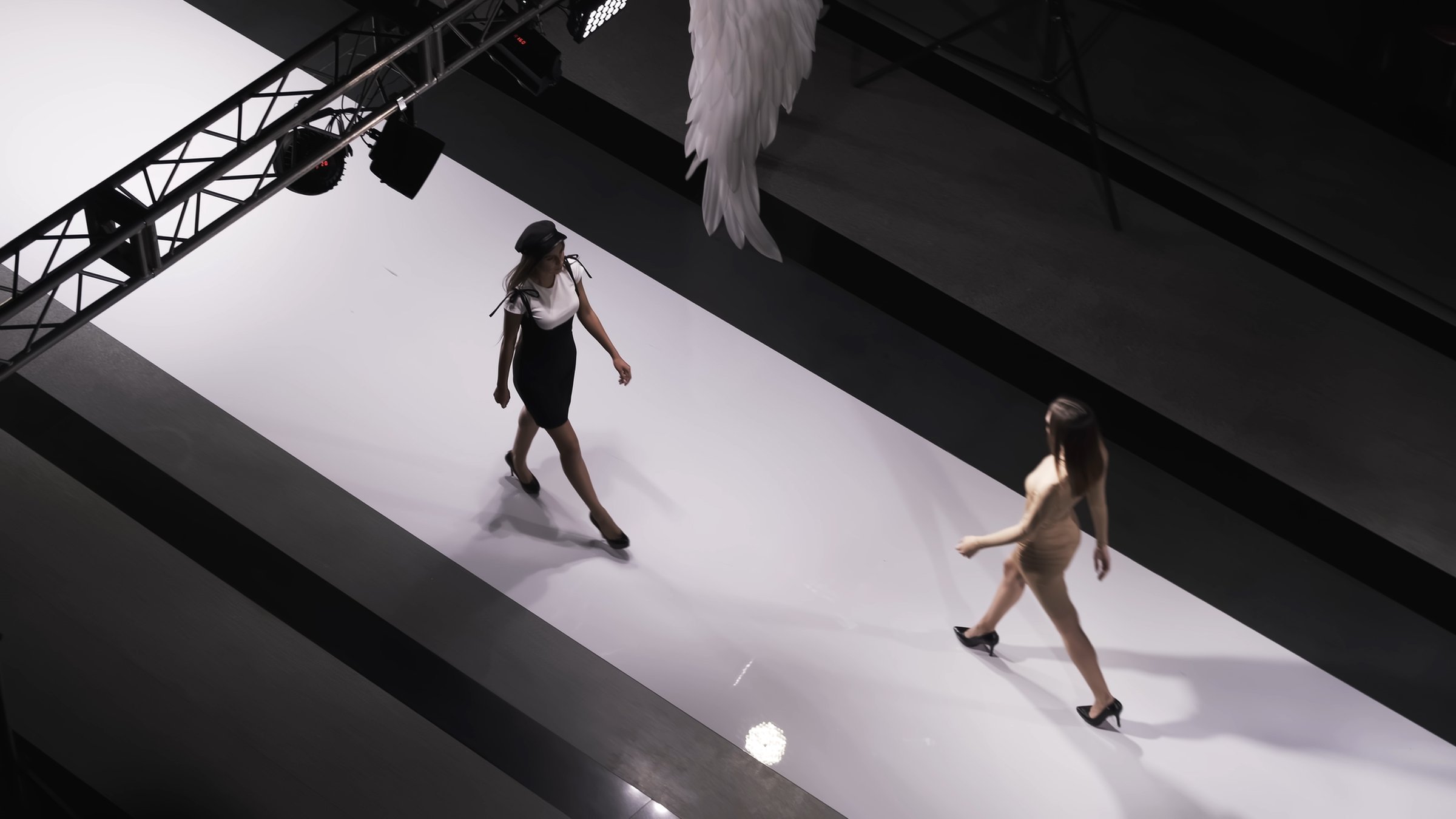 Fashion design female clothes woman on podium slow motion spotlights scene. Defile beautiful girl in colorful dress on catwalk model show close up evening vogue 4K.