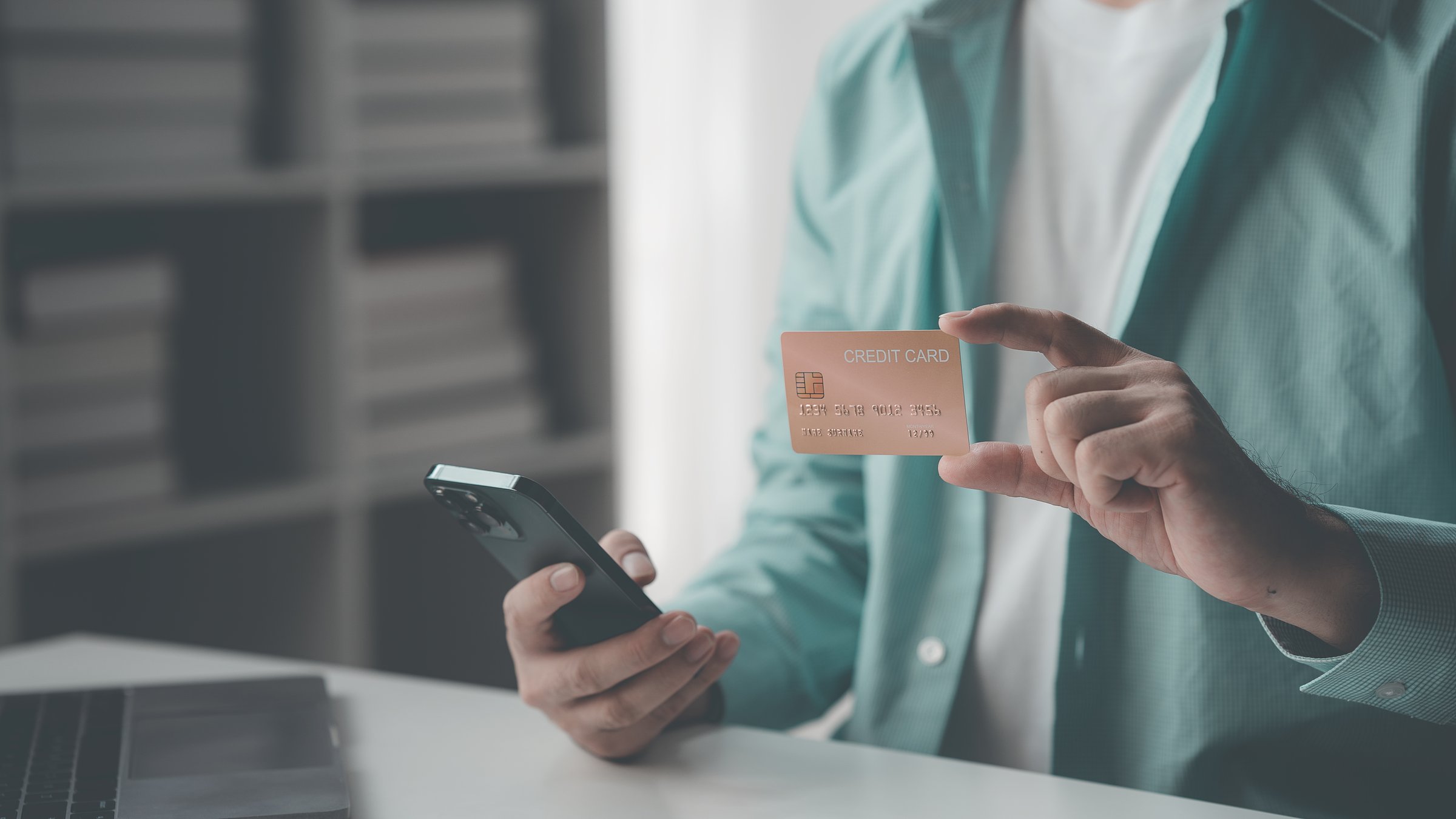 Male hand holding plastic credit card and smartphone. Online shopping. Secure online payment via e-banking. Close-up photo.