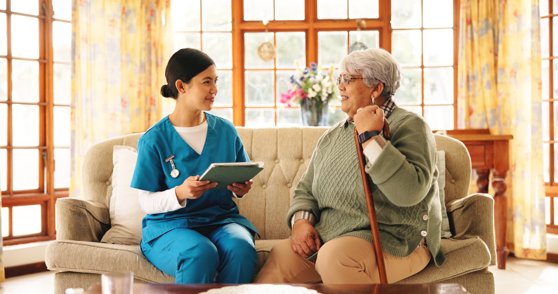 Tablet, old woman and caregiver in home for healthcare, results or consultation. Nurse, technology and happy senior patient in retirement for homecare, medical service or checkup with wellness update