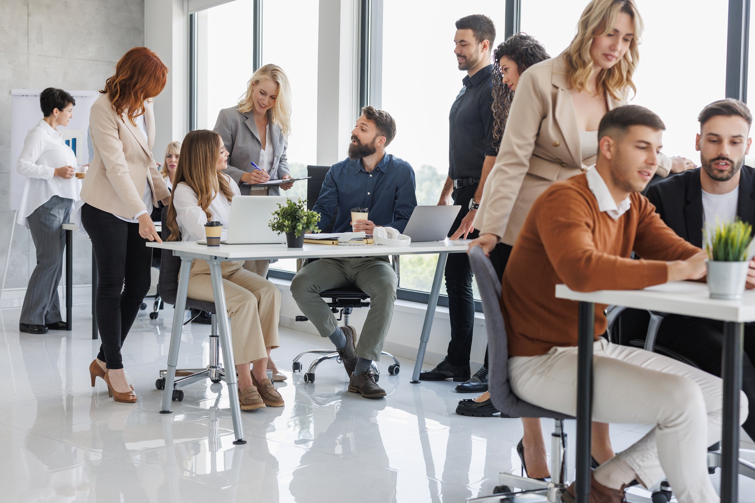 A diverse group of professionals engaging in a collaborative work environment in a modern office. Colleagues are discussing projects and ideas, fostering teamwork and productivity.