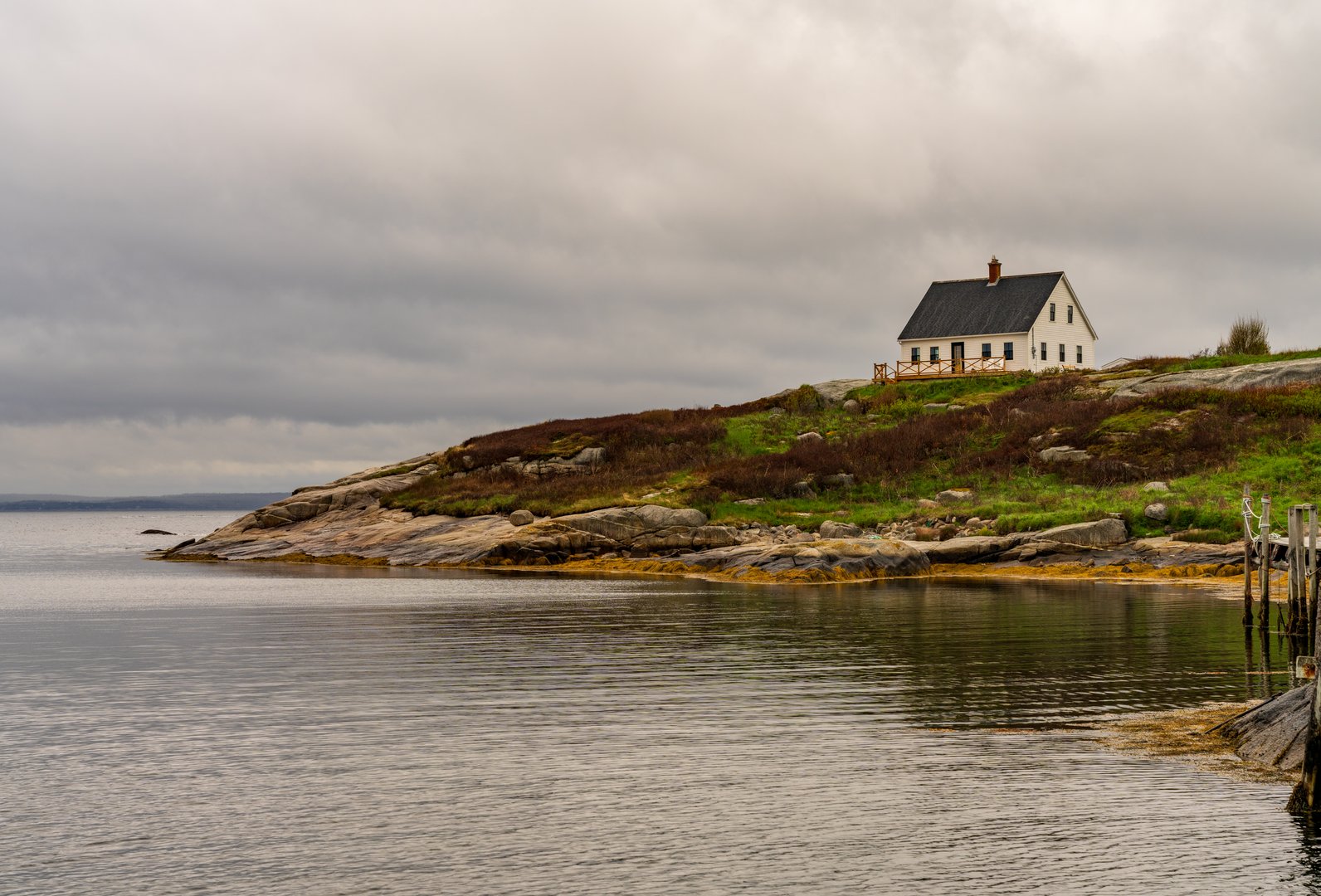 Solitary cottage overlooks the harbour of Peggys Cove near Halifax in Nova Scotia, Canada