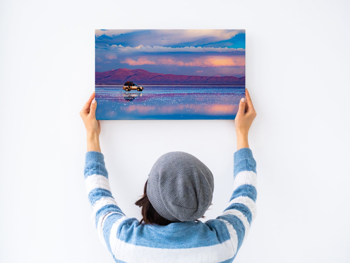 Girl hanging white canvas on wall
