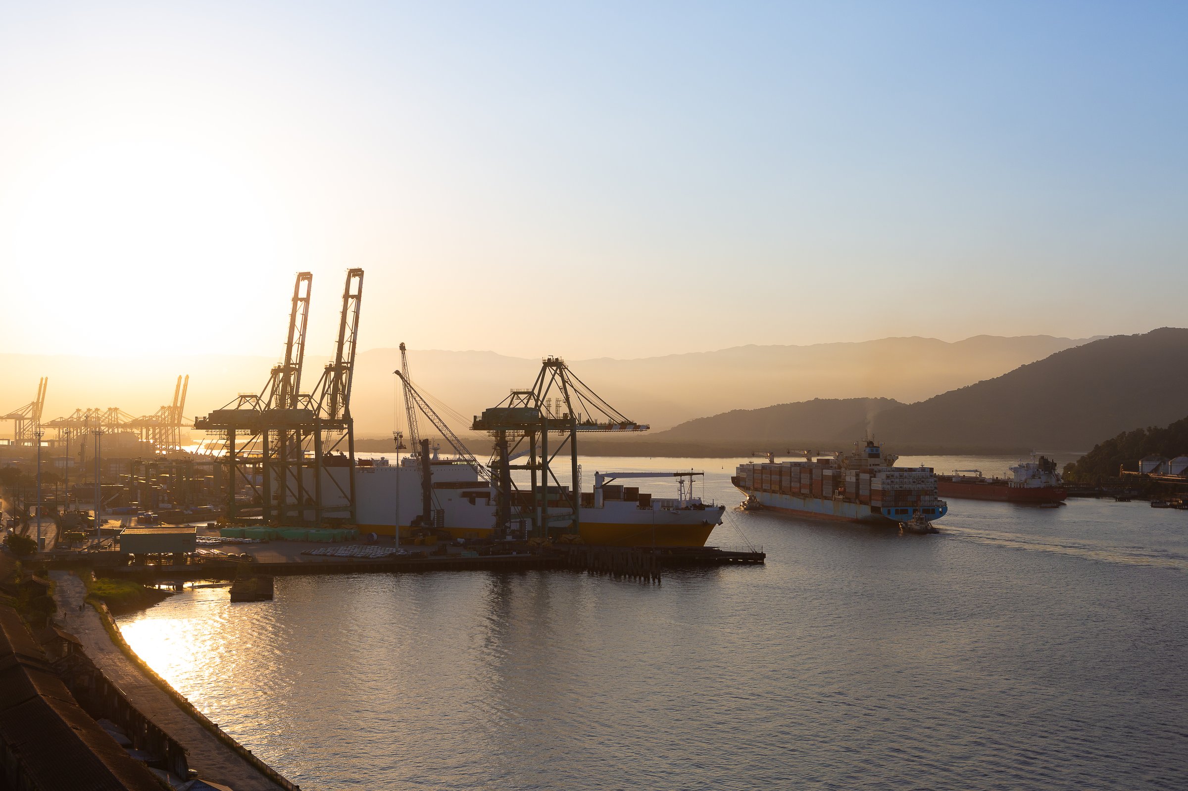 Movement in the port of Santos during sunset, with ships entering.
