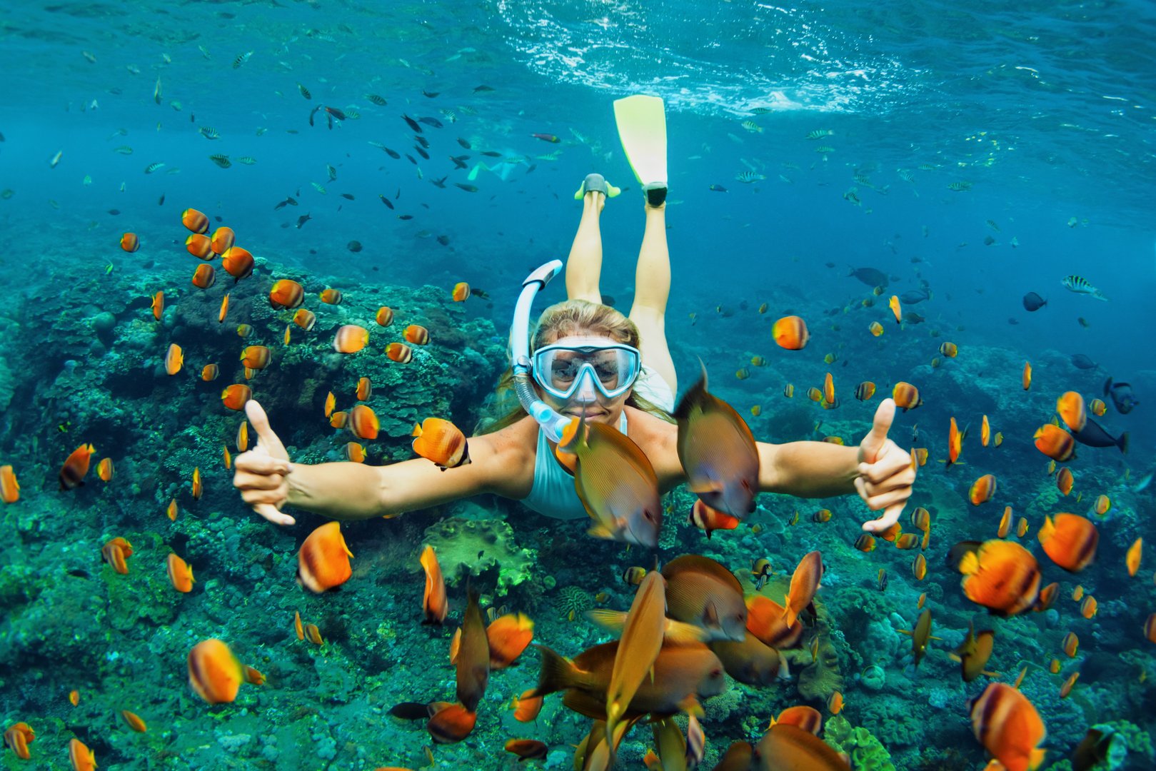 Happy family snorkeling with kids in coral reef sea pool