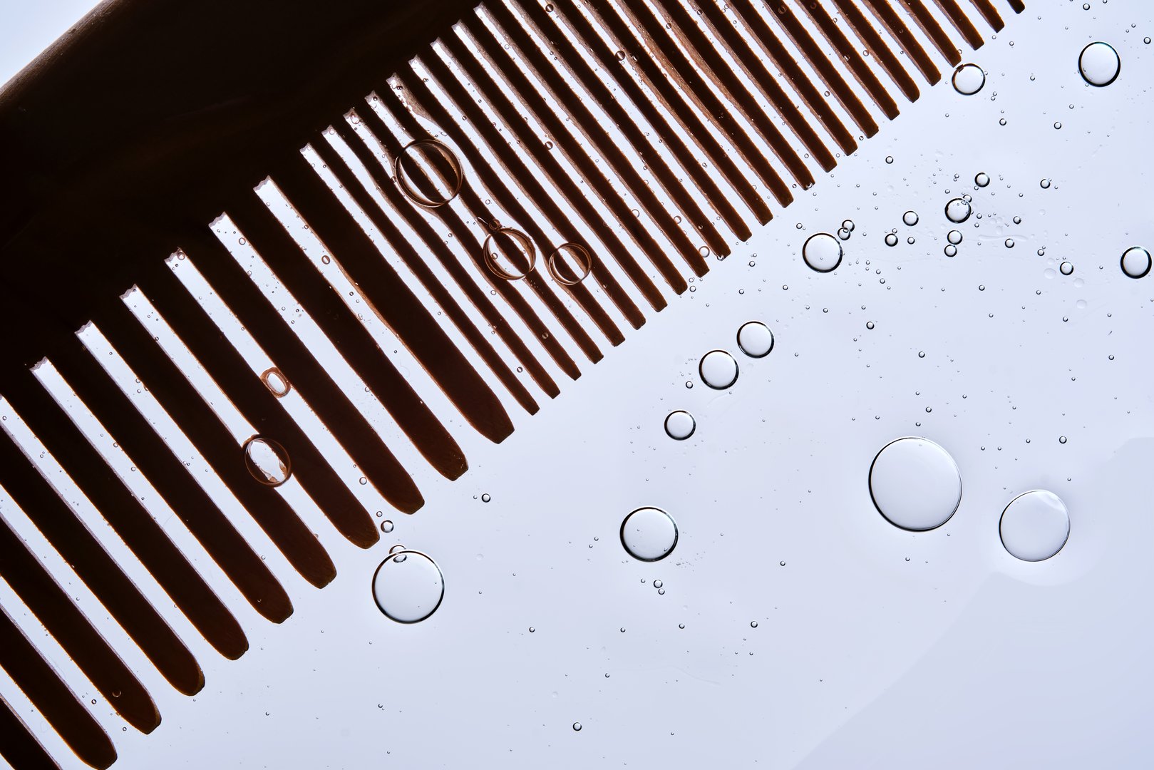 A comb with hair serum. The photo shows the texture of the cosmetic product. High quality photo.