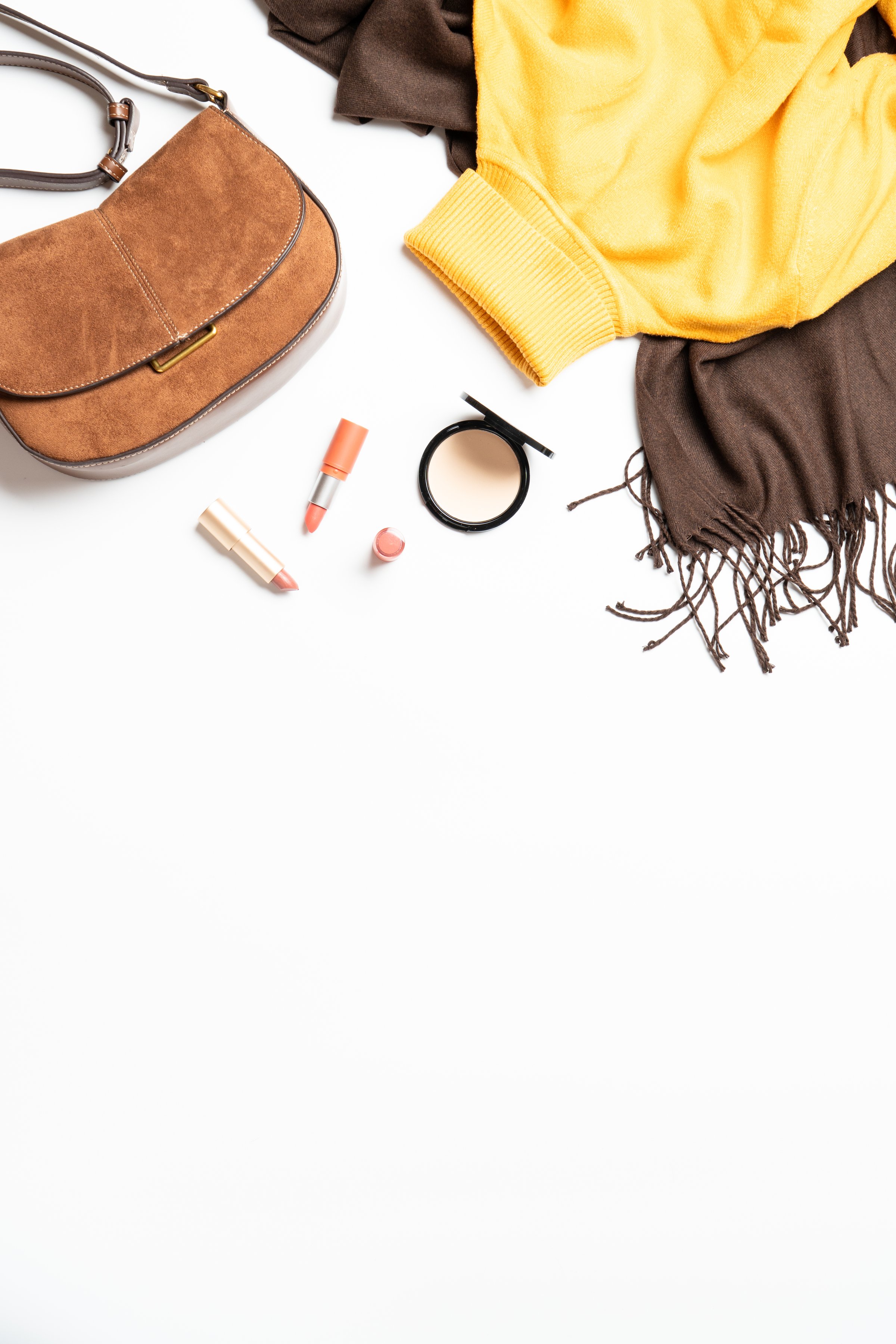 Autumn cloth and accessories at white background. Scarf, yellow sweater and bag. Flat lay with copy space.