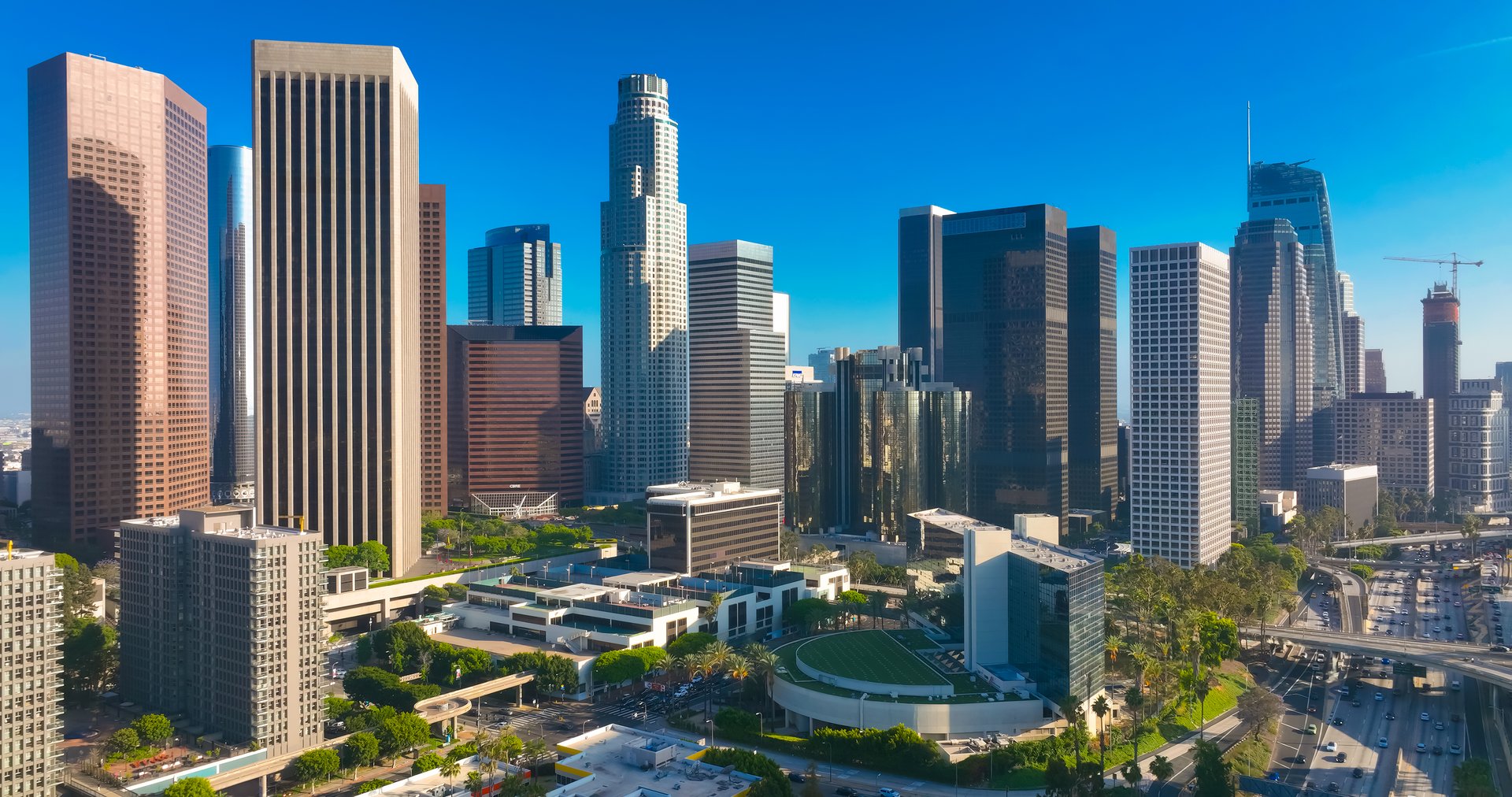 Los Angeles city. LA downtown aerial view. Los Angeles skyline. LA streets. Los Angeles from a top view. Downtown towers of Los Angeles. Panoramic scene of LA skyline. Blue sky frames the city below