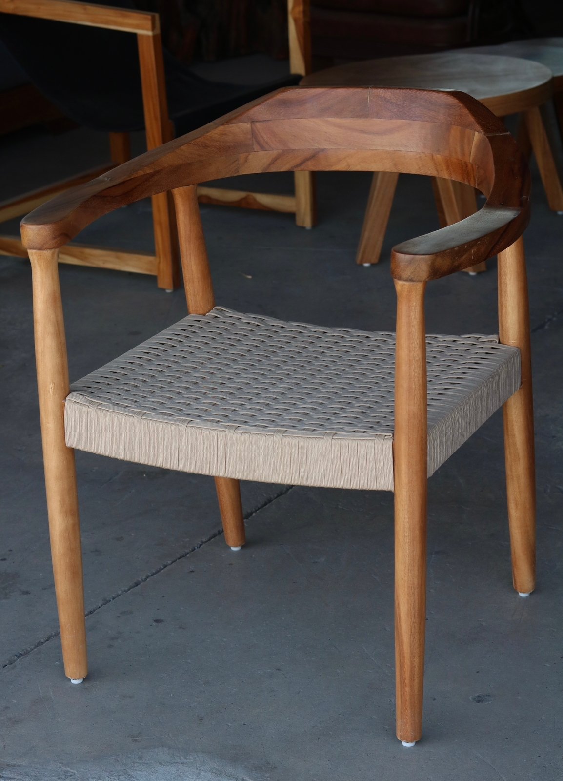 Silla con respaldo-brazos en pieza curva y asiento tejido a mano en cordón de nailon náutico