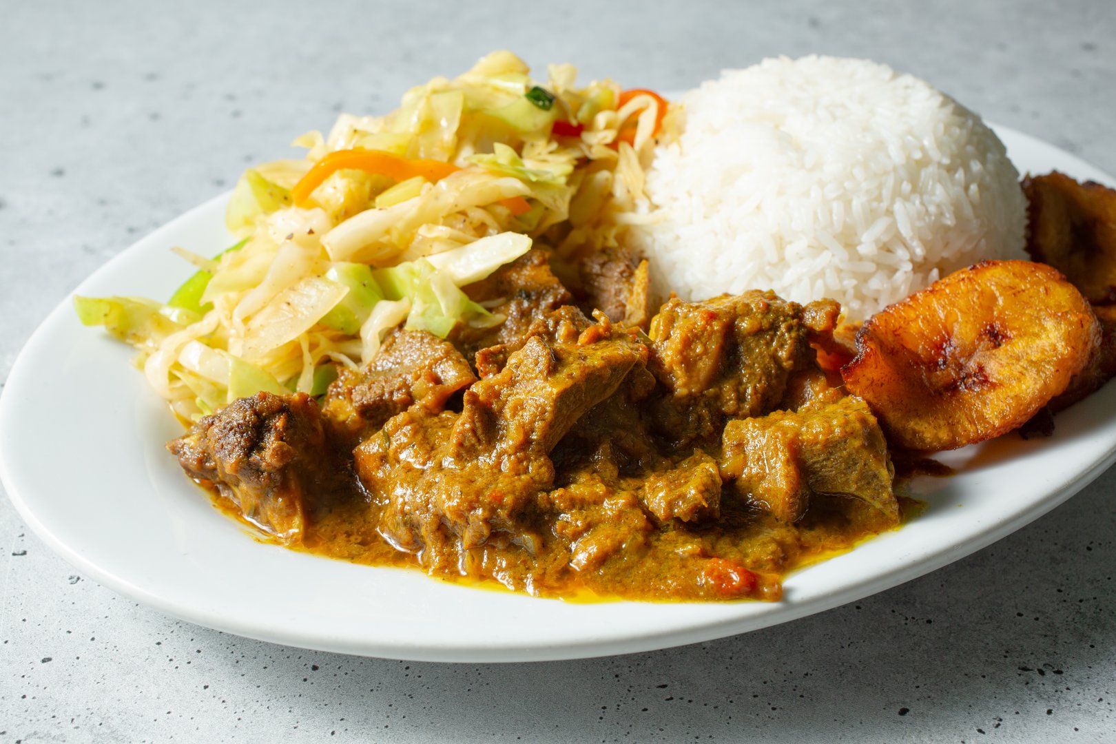 A view of a plate of curry goat.