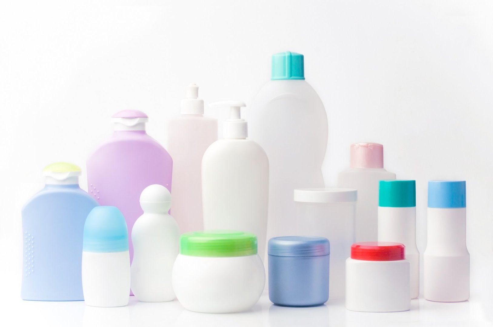 Various cosmetic containers in different shapes and colors on a white background, including bottles, jars, and deodorants.