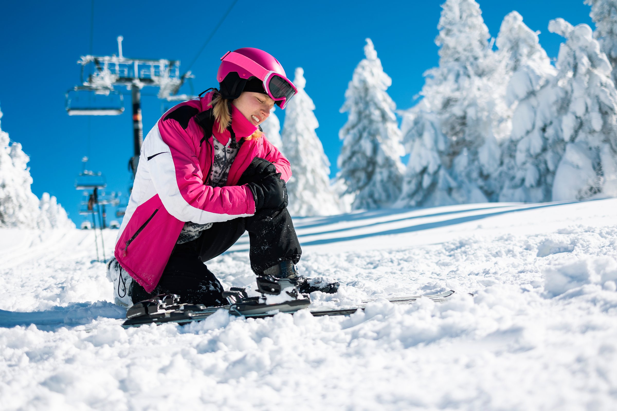 Young sportswoman rubbing her hit knee after crash.