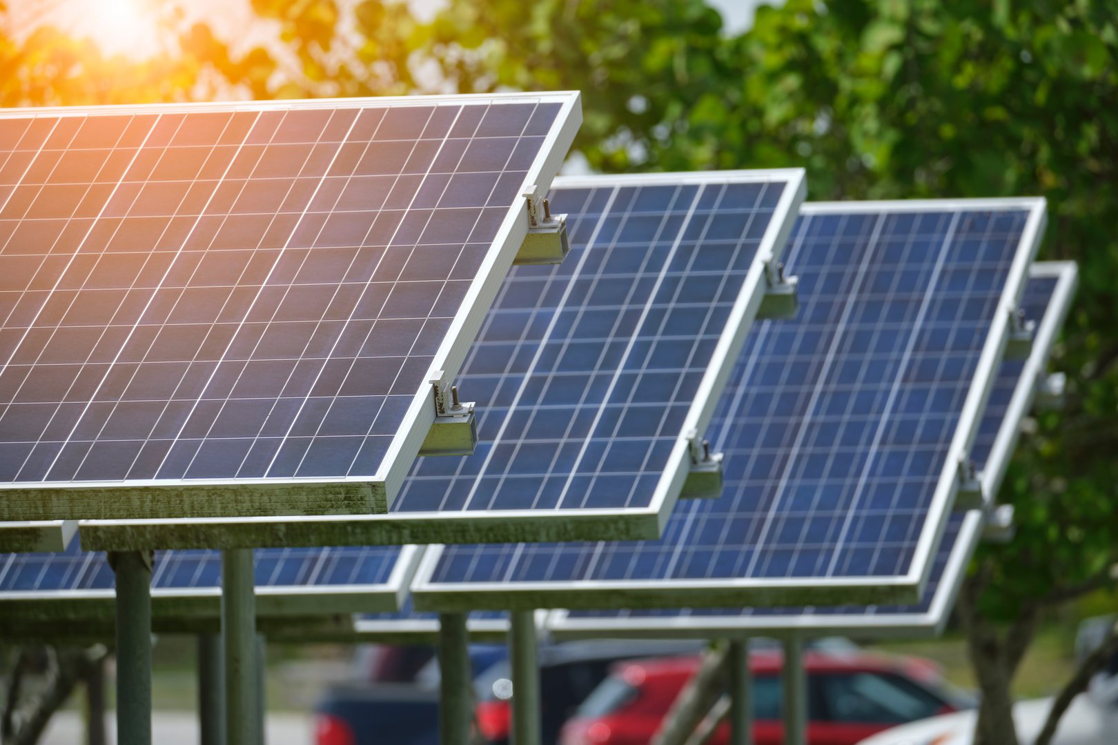 Solar panels installed on stand frame near parking lot for effective generation of clean electricity. Photovoltaic technology integrated in urban infrastructure for electric car charging.