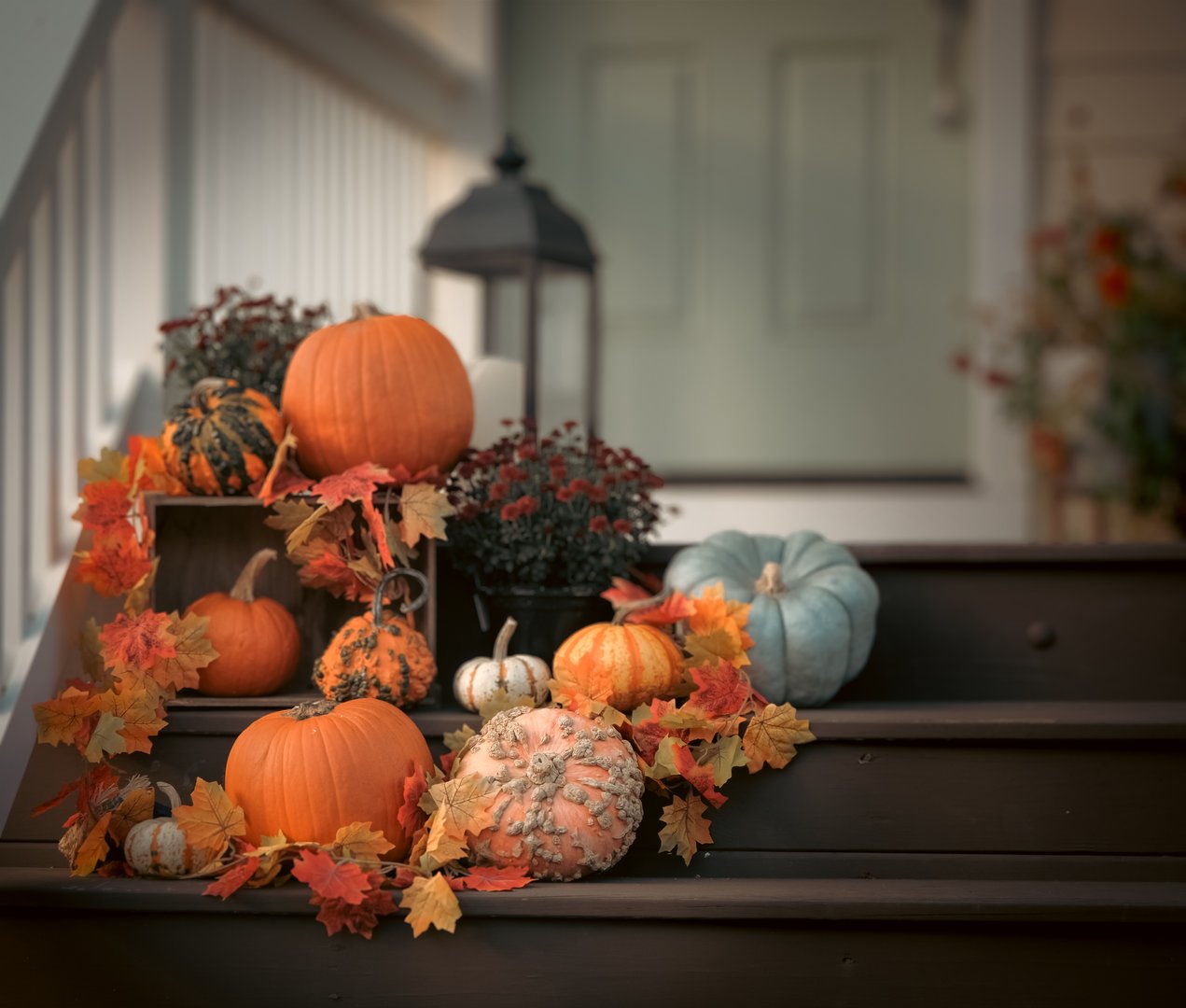 Fall displayed with pumpkins and autumn leaves on front steps.