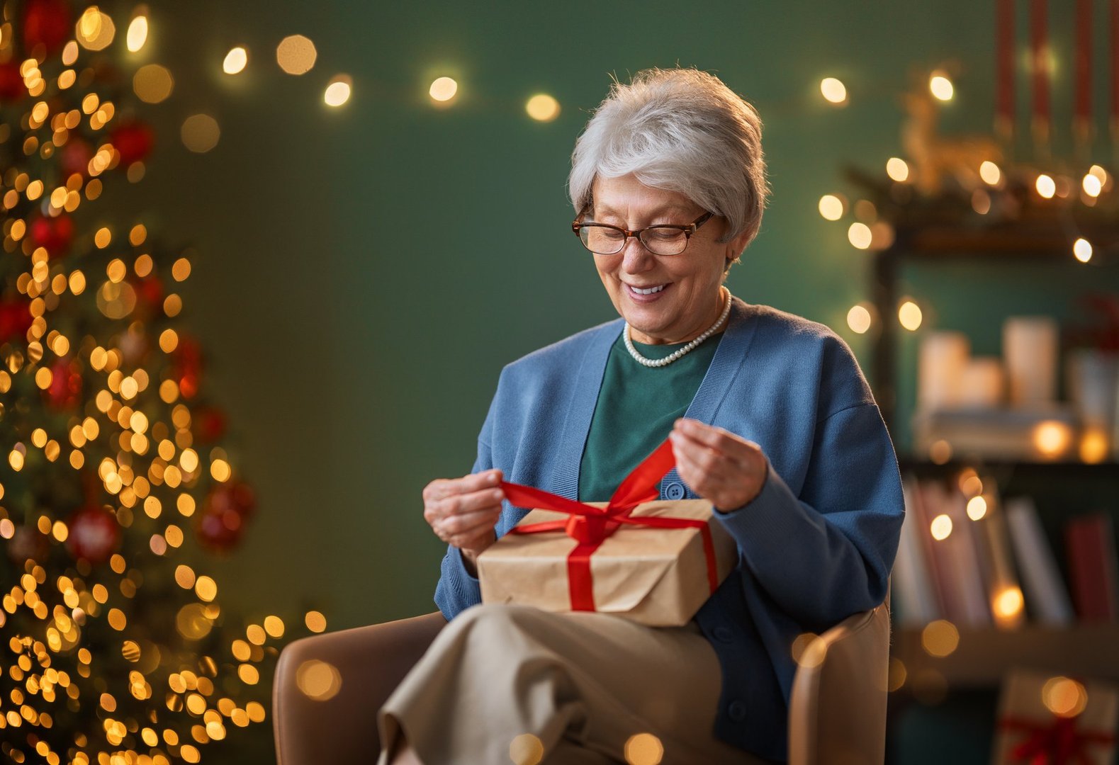 Merry Christmas, Happy Holidays. Cheerful senior woman having got a Christmas present.