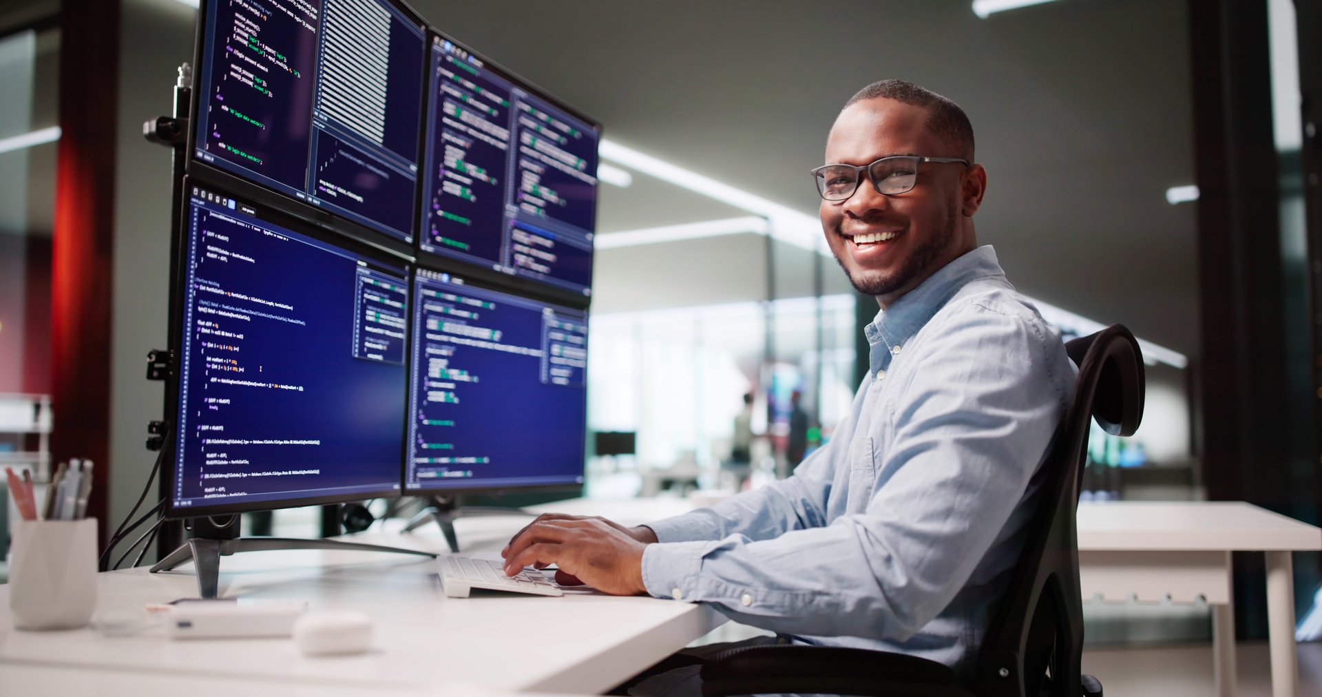 Happy African American Web Developer Coding At Office Desk Screen
