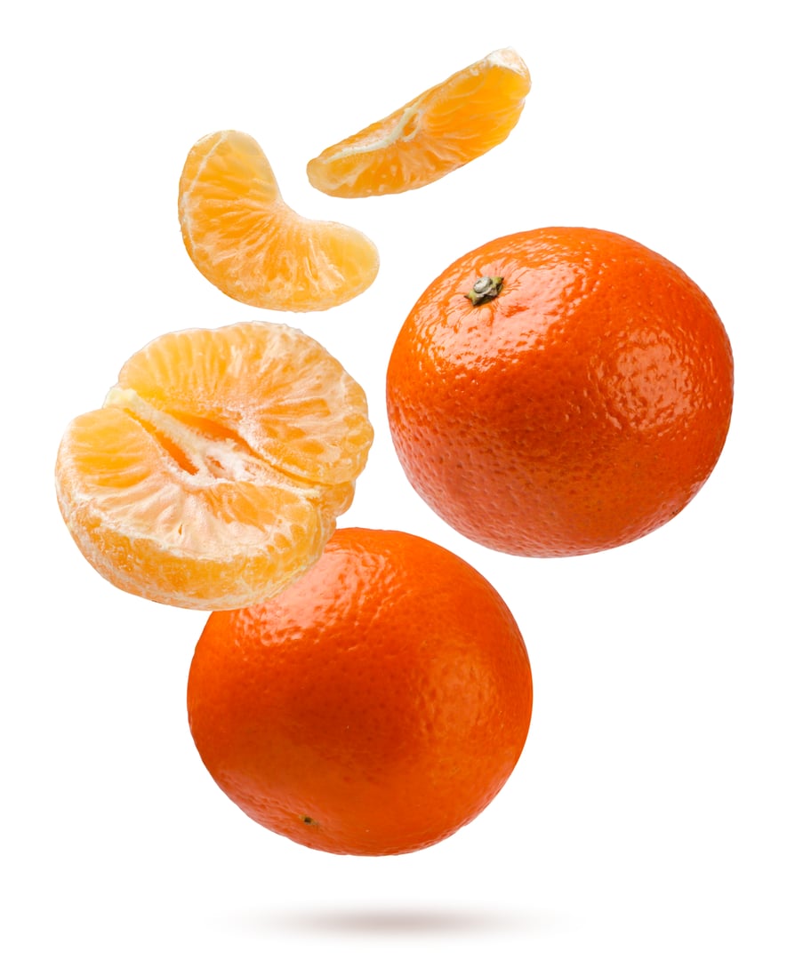 Ripe tangerines, halves and slices fly close-up on a white background. Isolated