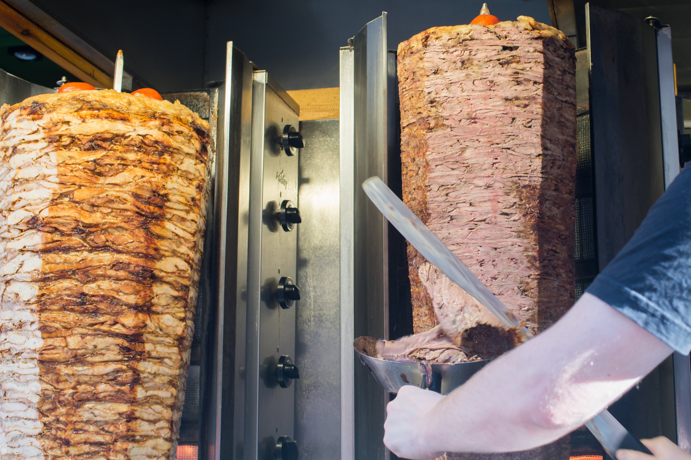 Unrecognizable person cooking turkish kebap or kebab on a rotating grill. Istanbul, Turkey
