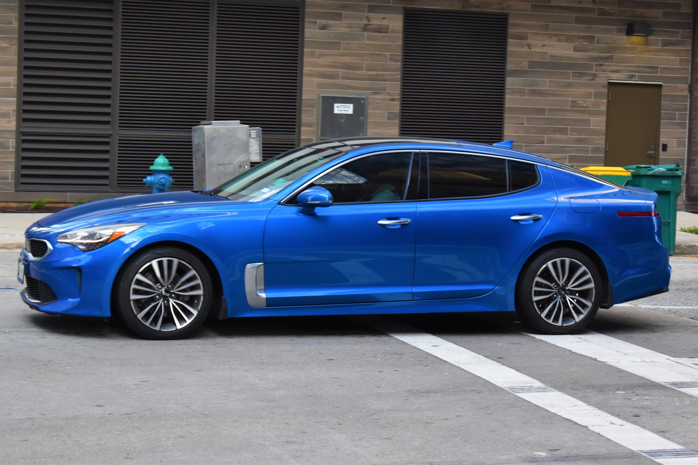 Houston, TX USA 10-4-2024 - Portrait of a black, blue, and silver Kia Stinger sedan traveling in the downtown financial district of Houston.