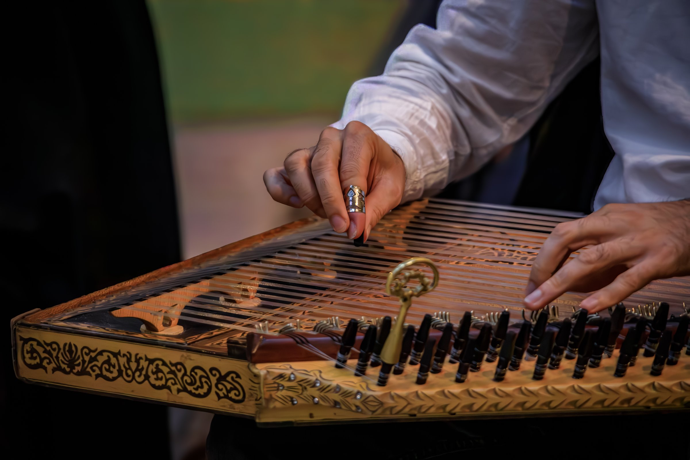 Close up of a musician s hands playing a traditional ornate Turkish Kanun, a Middle Eastern stringed instrument using metal picks in Istanbul, Turkey