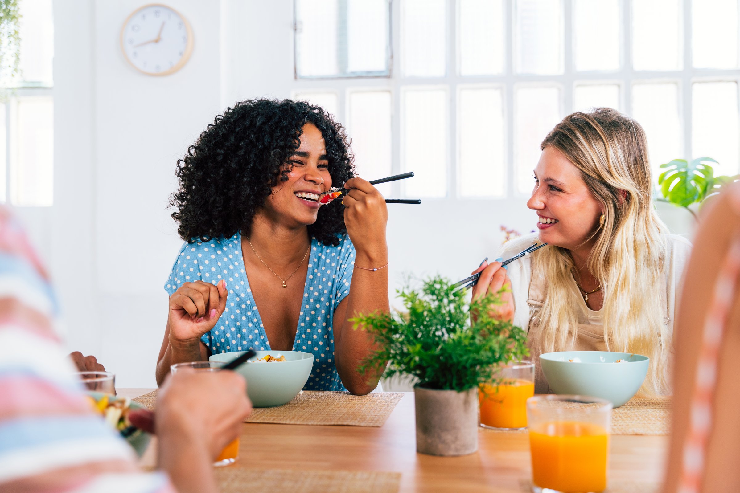 Multiethnic group of young friends meeting at home and eating poke bowls - Multiracial happy people bonding while having lunch