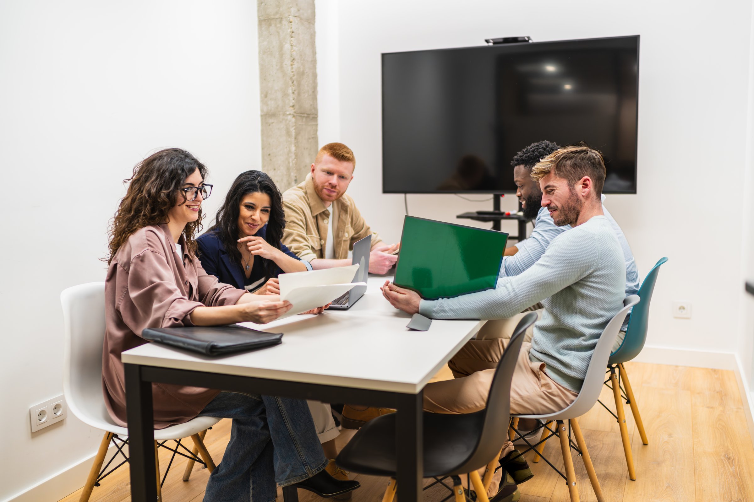 Five young professionals are having a productive meeting in a modern coworking space
