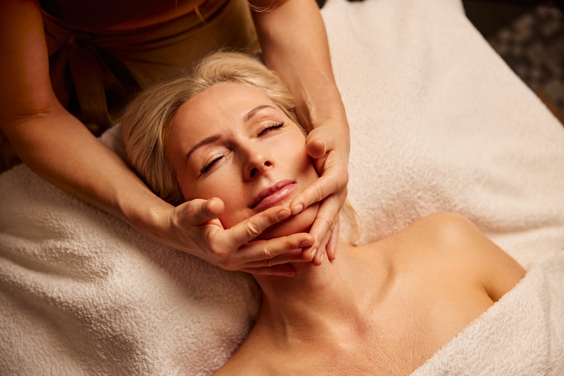 Serene Spa Experience with Relaxing Facial Massage. A woman enjoys a calming spa treatment with a gentle facial massage