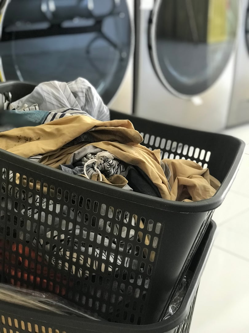 The laundry piled up in the basket is ready to be washed in the washing machine